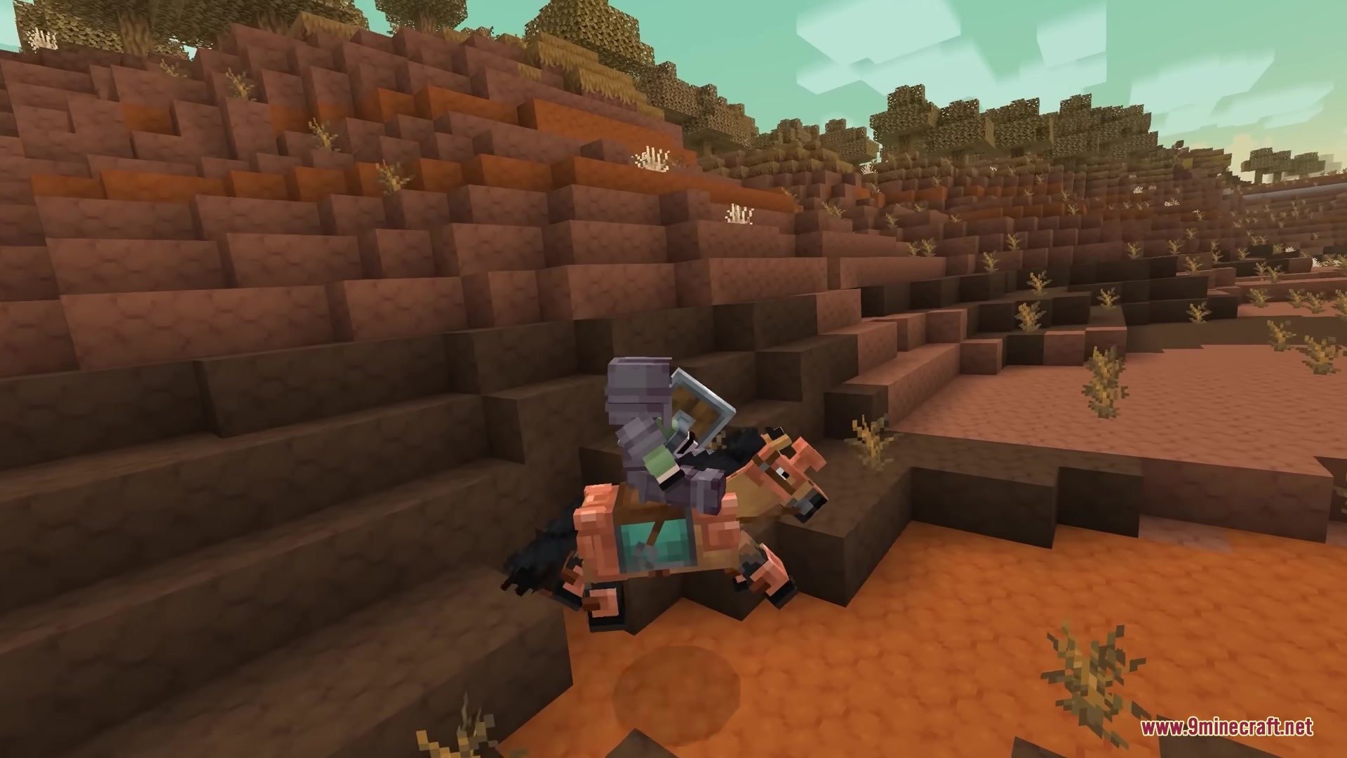 A player in full armor rides a horse across a desert mesa