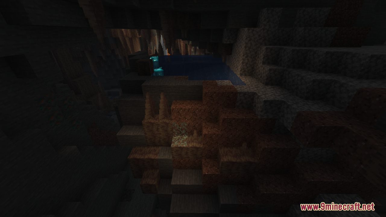 A dark cave interior featuring a small pool of water and stalactites