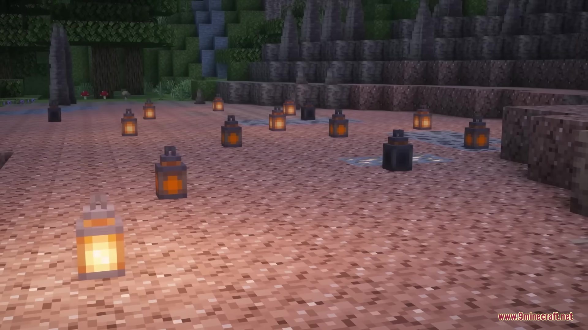 Multiple lanterns with varying brightness levels placed on the ground outside