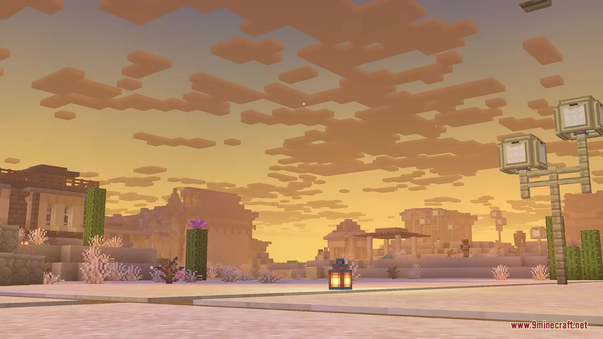 A desert village under a sunset sky filled with soft fluffy clouds