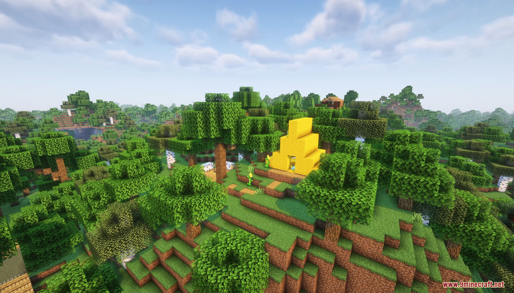 A yellow tent sits on a hill overlooking a vast green forest landscape