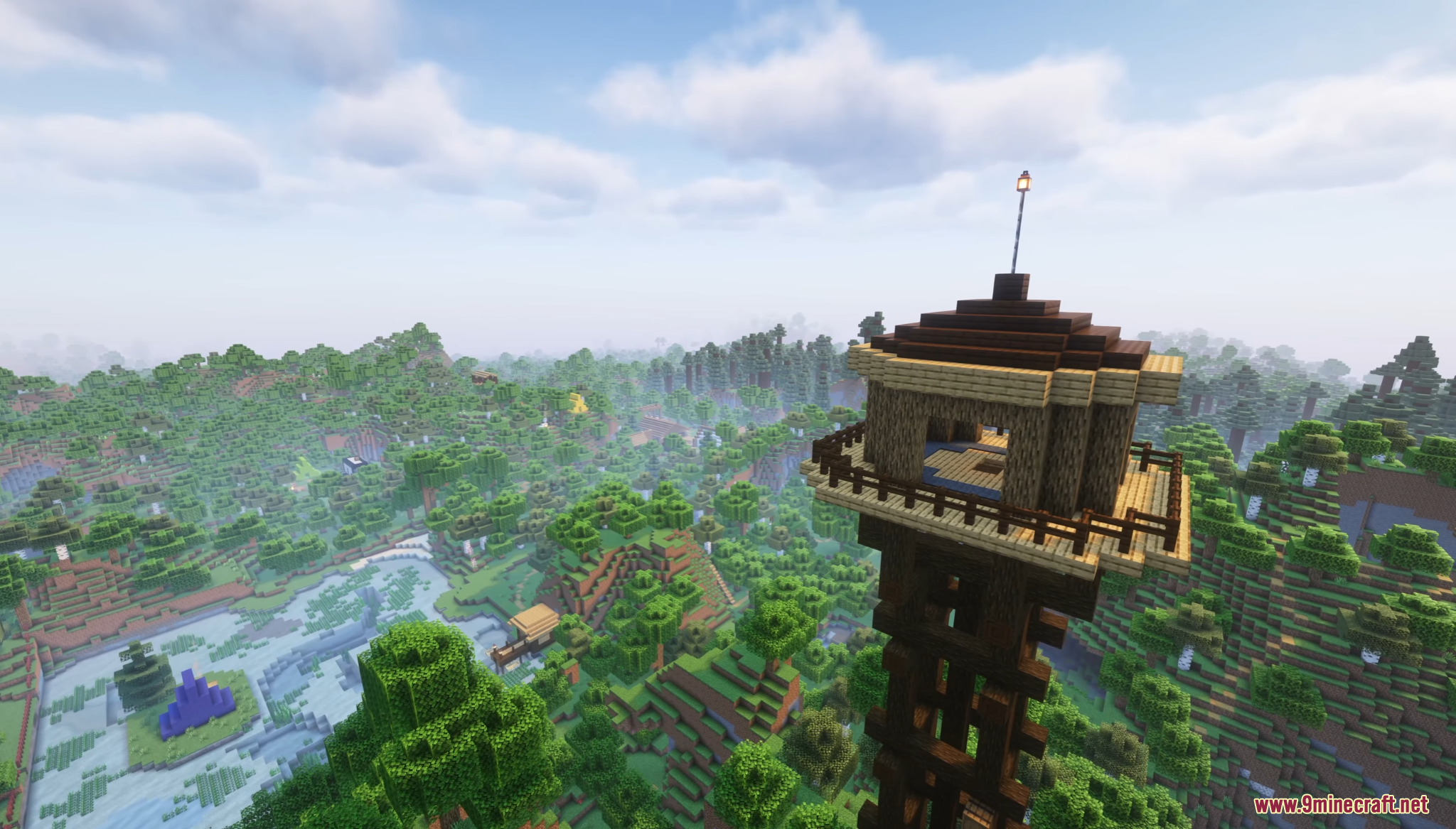 A tall wooden watchtower standing above a dense and lush green forest