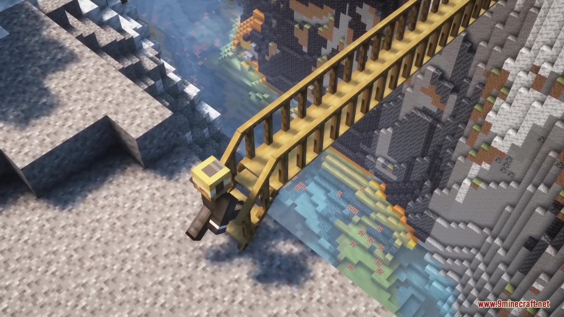 A player character walks across a wooden bridge over a snowy mountain ravine