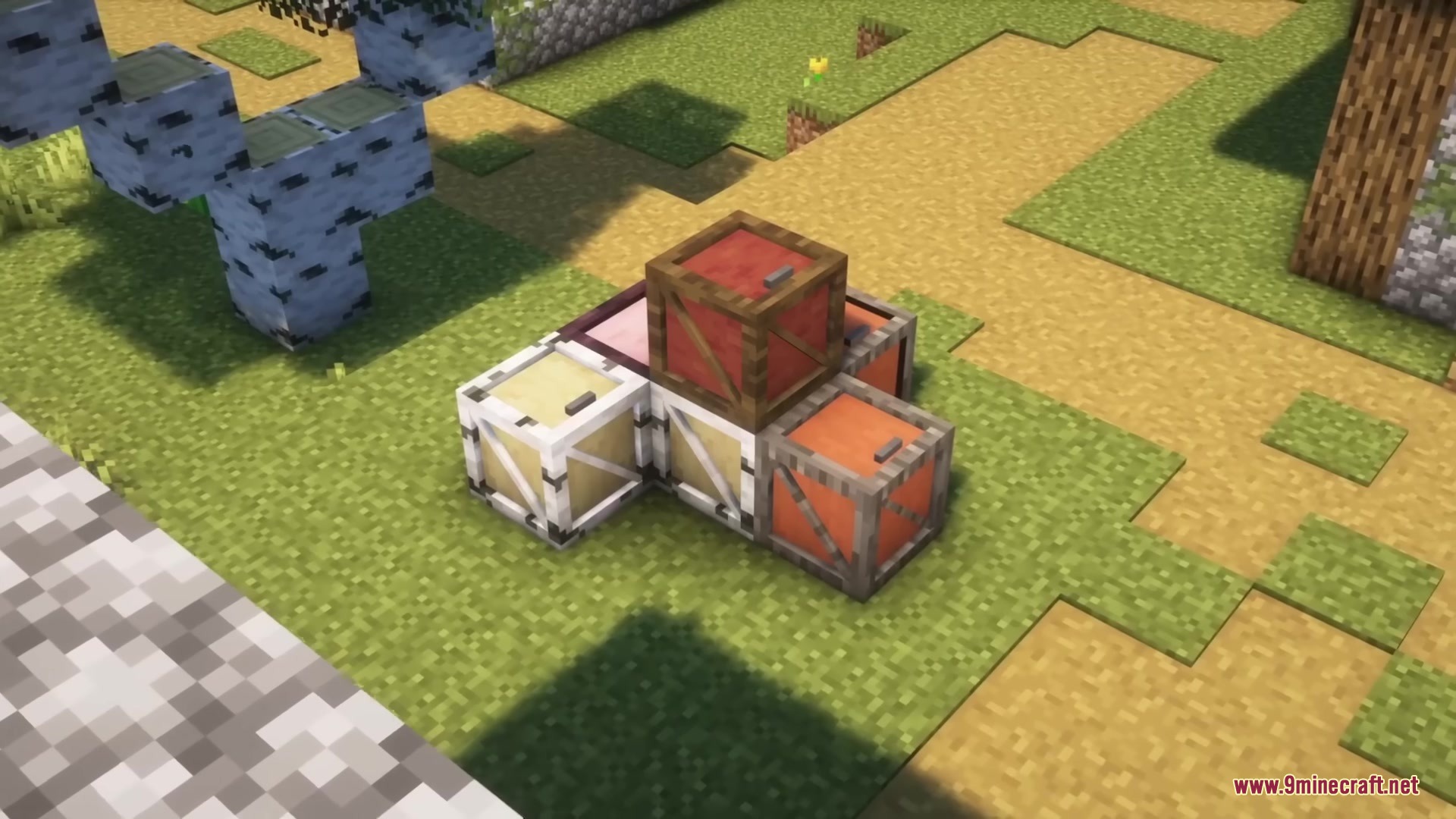 A stack of colorful wooden crates placed on a grassy path