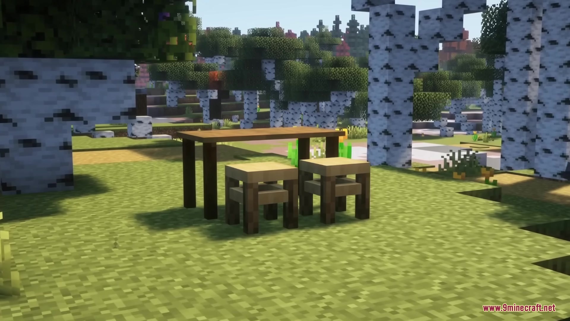 A wooden table and two stools placed outside in a birch forest
