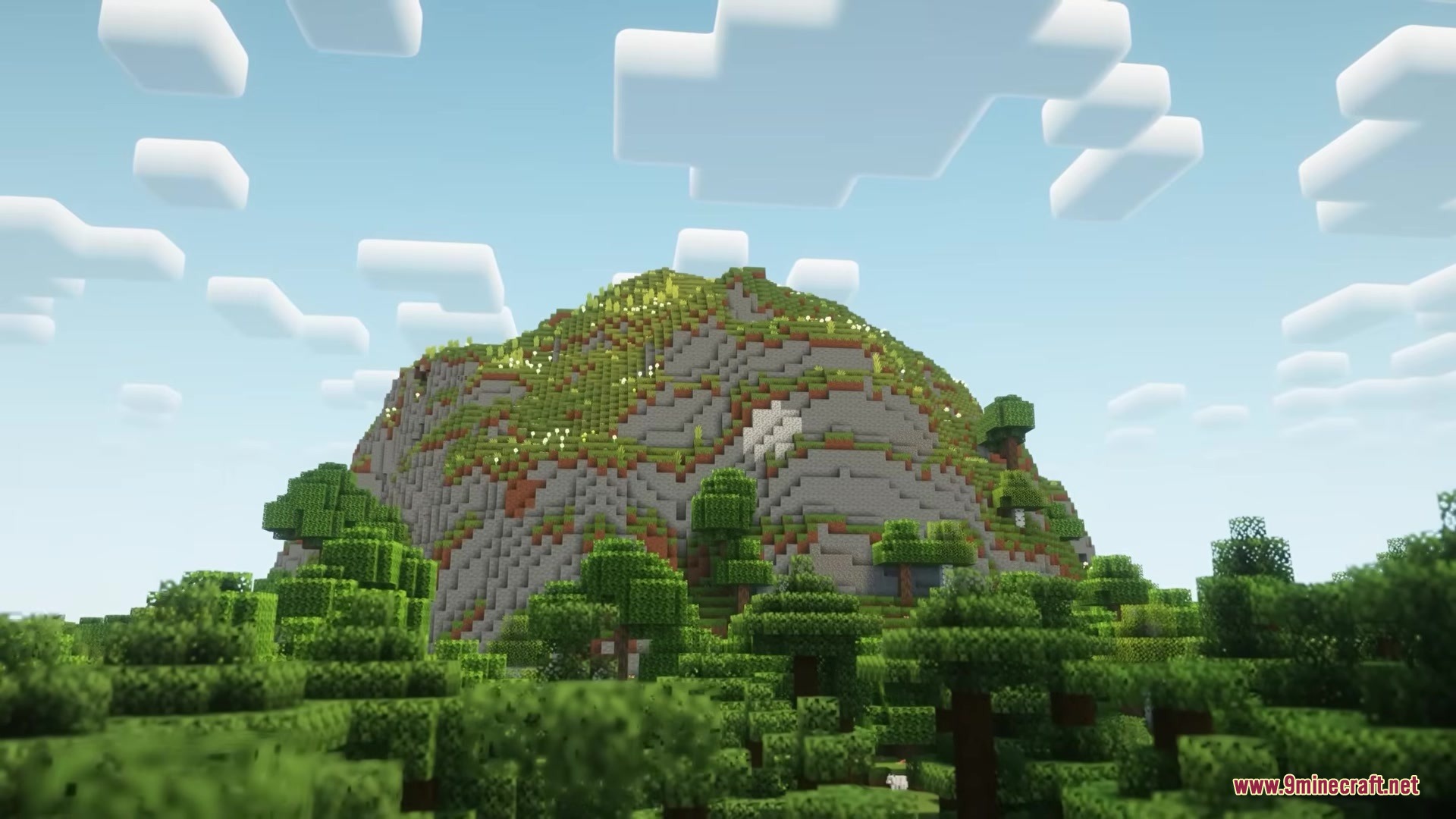 Garden Trails Mod Screenshot 4 Large grassy mountain surrounded by a dense forest of green trees in Minecraft