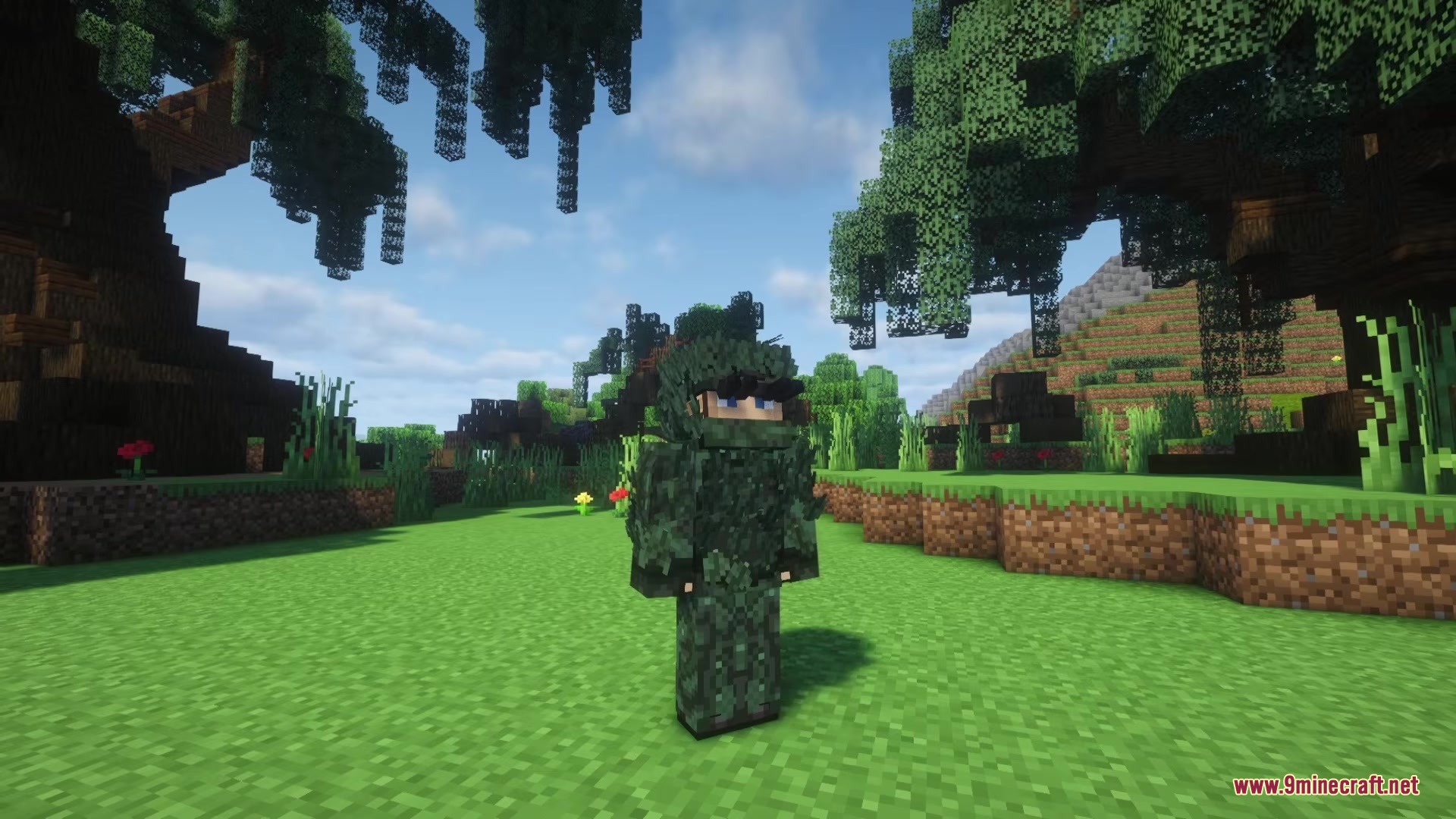 A Minecraft player wearing green camouflage armor stands in a sunny forest