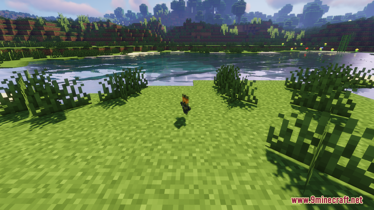 A small futuristic totem item floating on the grass near a lake