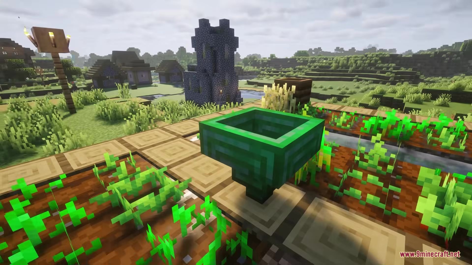 Hopper Plus Mod Screenshot 9 A green emerald hopper placed on a farm overlooking a small village