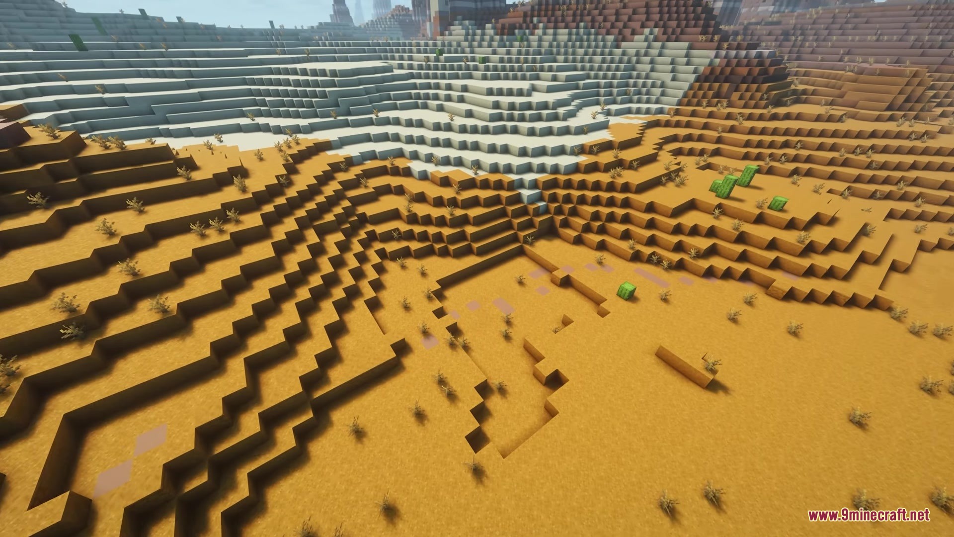 A sandstone road winding through a vast desert biome with cacti and bushes