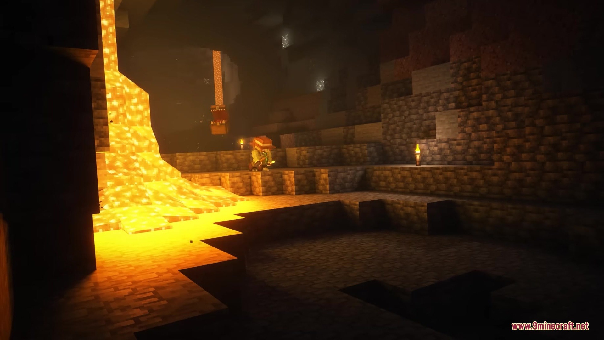 A character stands near a lava fall in a large underground cavern