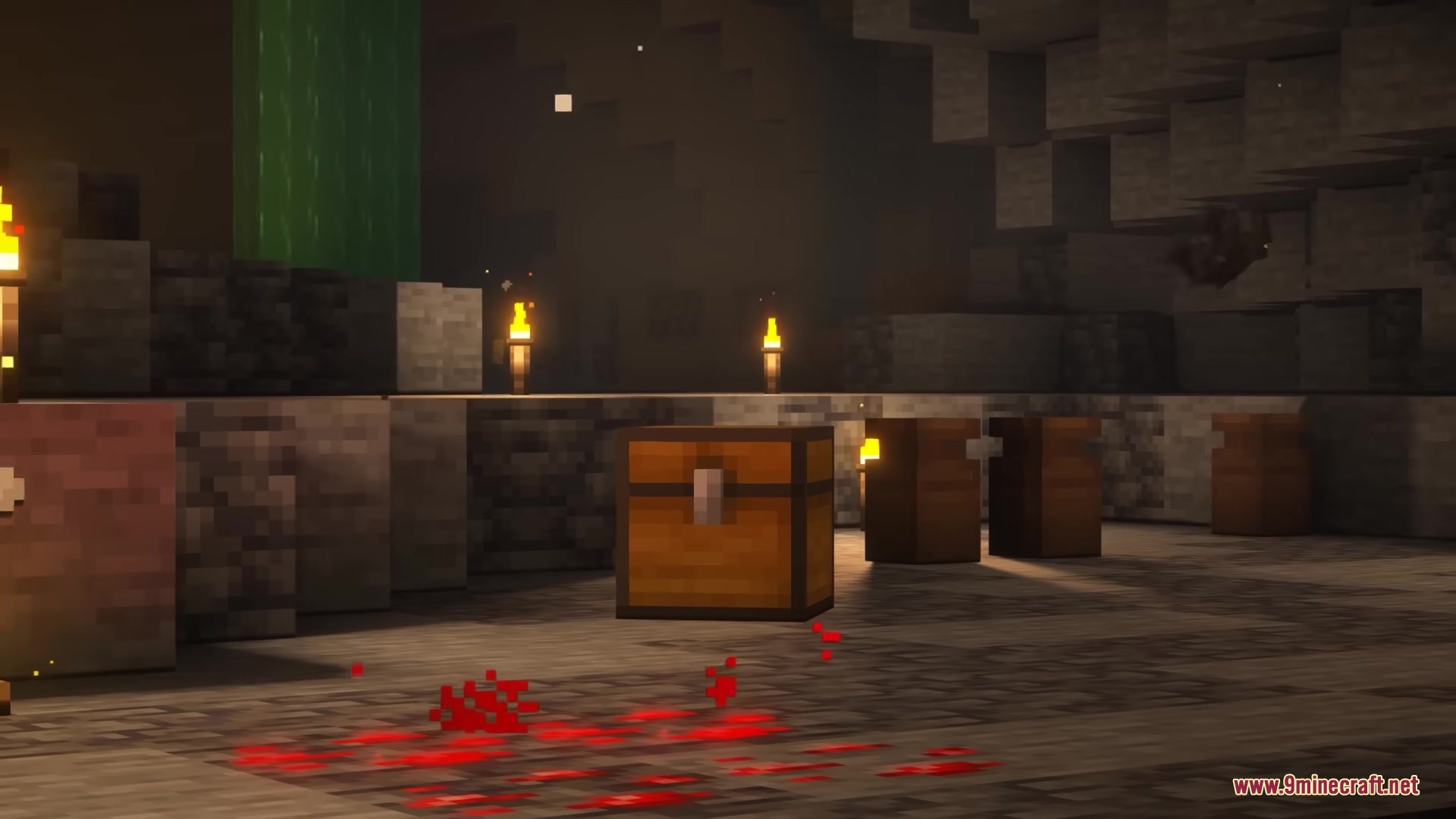A wooden chest in a dark cave with red particles on the floor