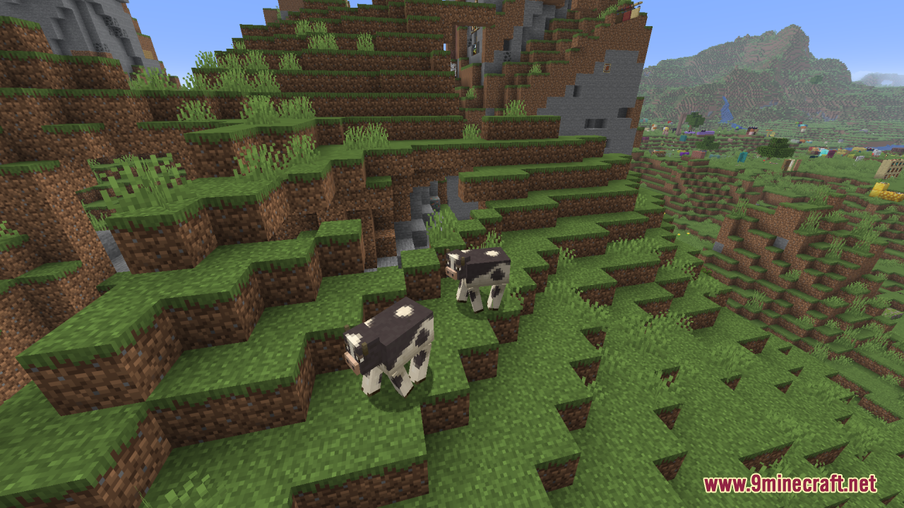 Mizuno's Cow Variants Resource Pack Screenshot 4 Two spotted cows walking along a steep grassy slope in a hilly biome