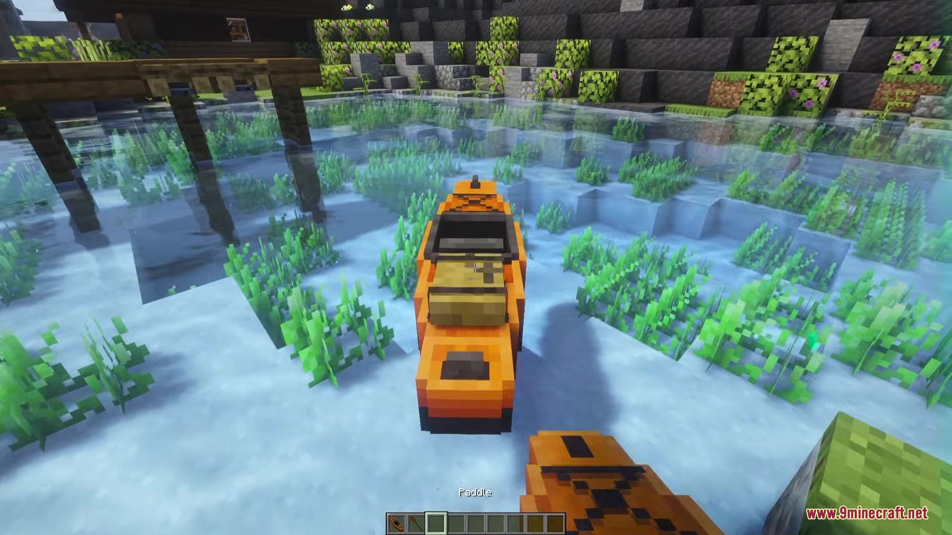 First person view of an orange kayak floating in clear river water