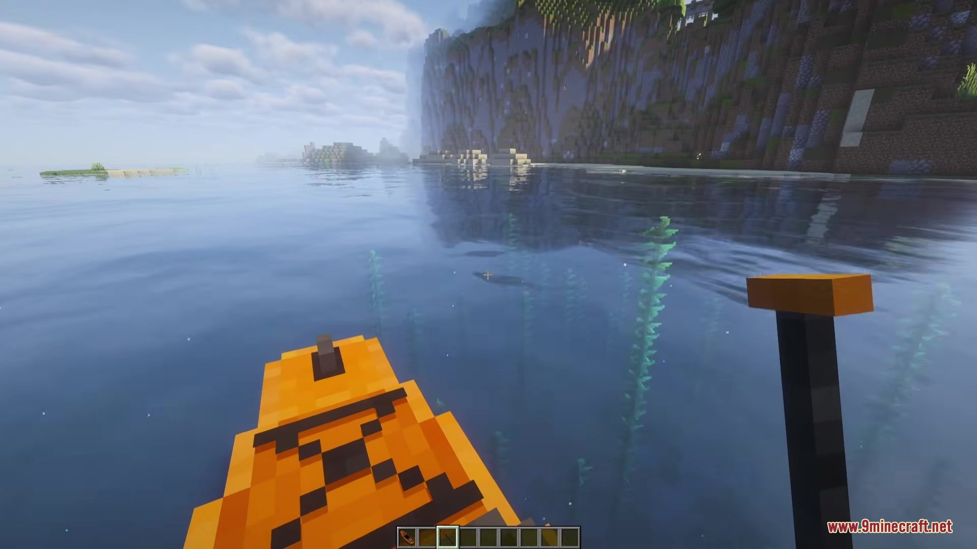 First person perspective of a player paddling an orange kayak through clear water