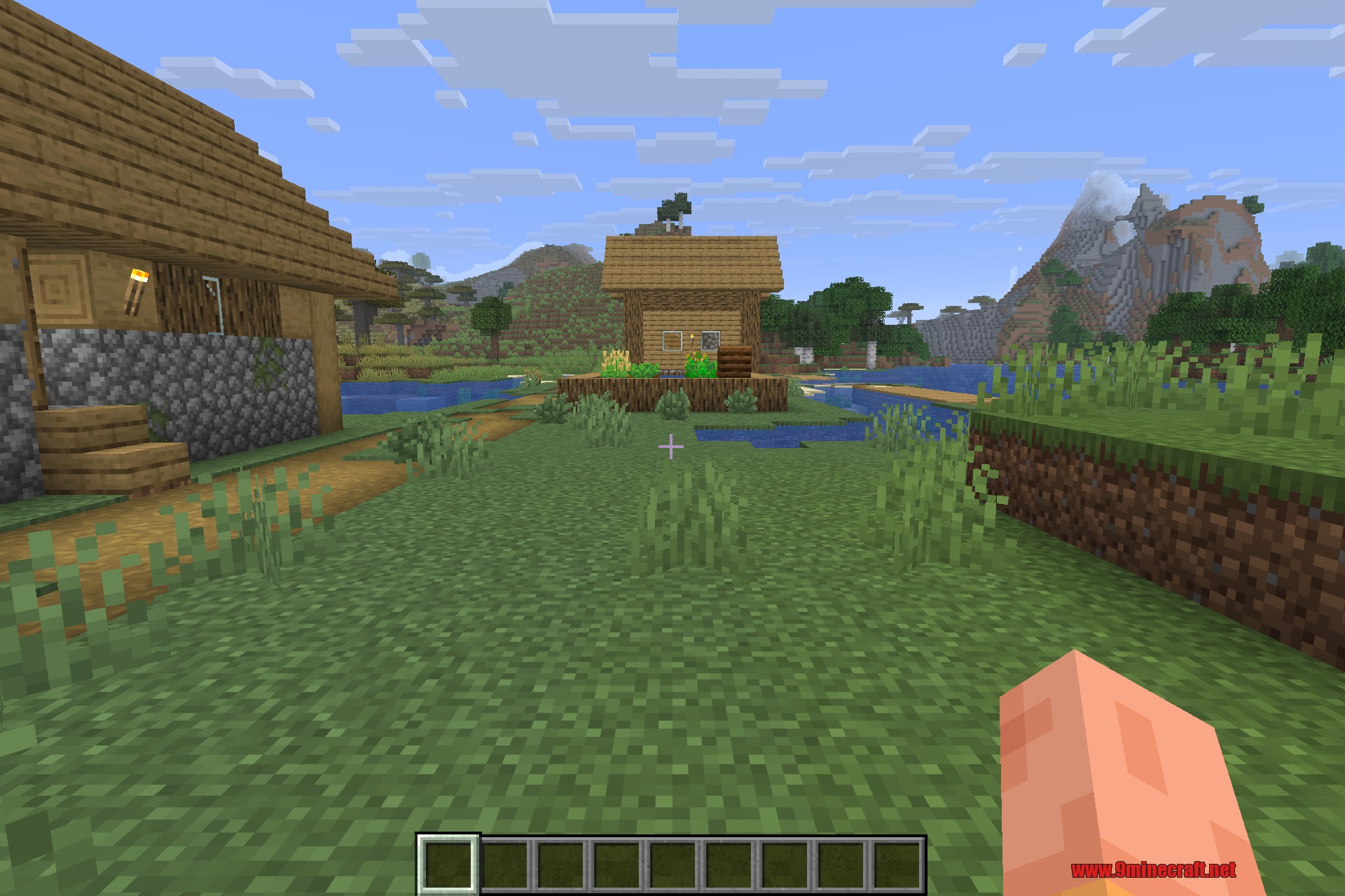 Overhauled Village 9minecraft Mod Screenshot 4 A player looks at a village house with a mountain in the background