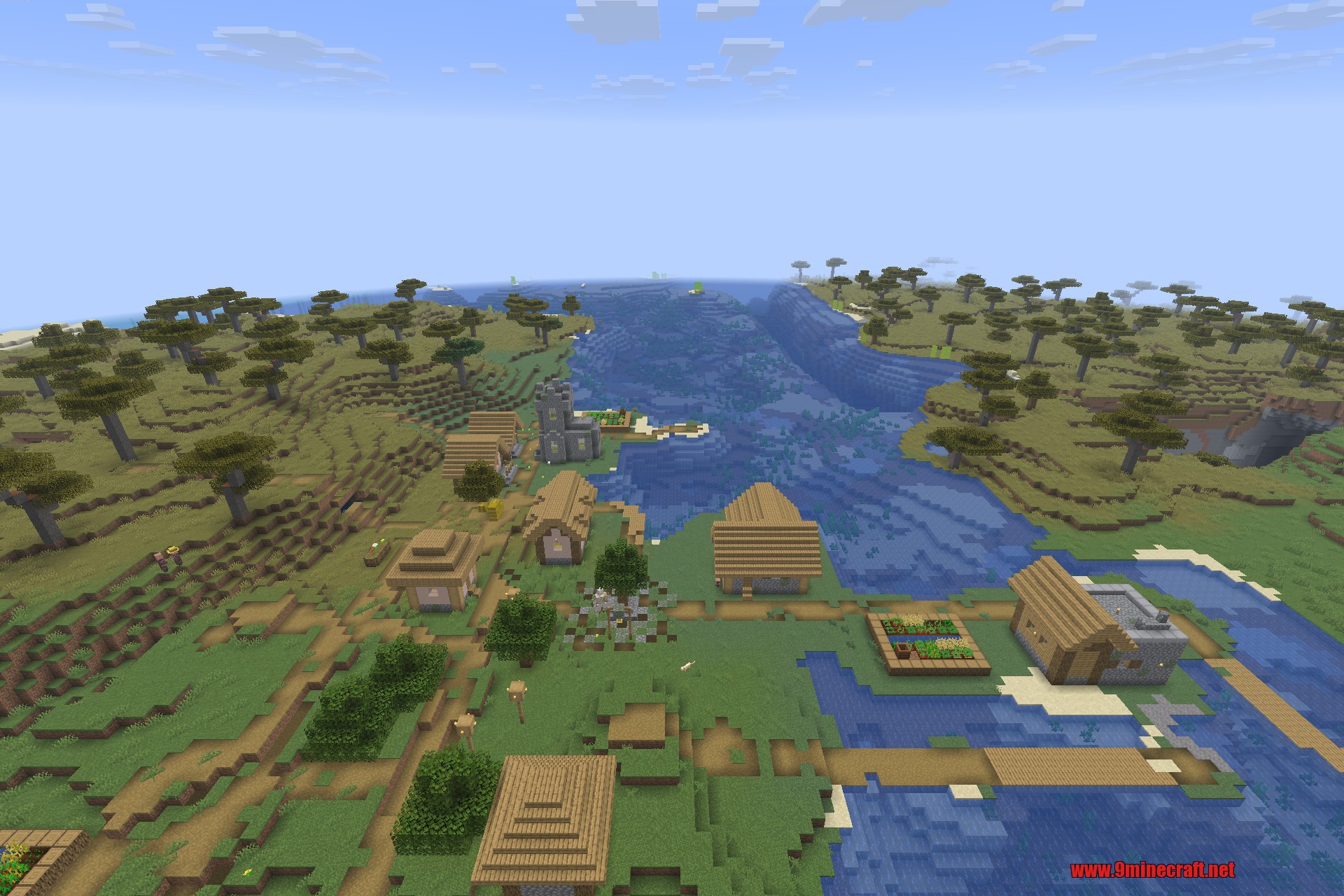 Overhauled Village 9minecraft Mod Screenshot 5 Detailed savanna village featuring custom houses and a stone church near the water