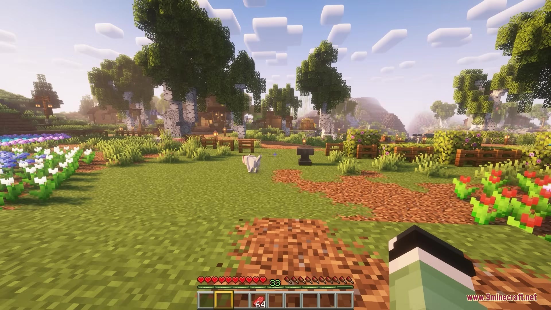 A white wolf stands near an anvil in a lush garden landscape