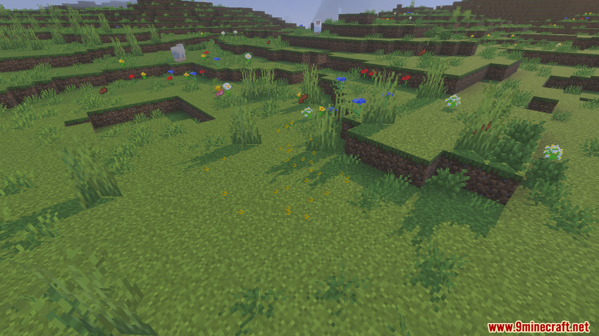 Various flowers and dropped items scattered across a hilly Minecraft landscape