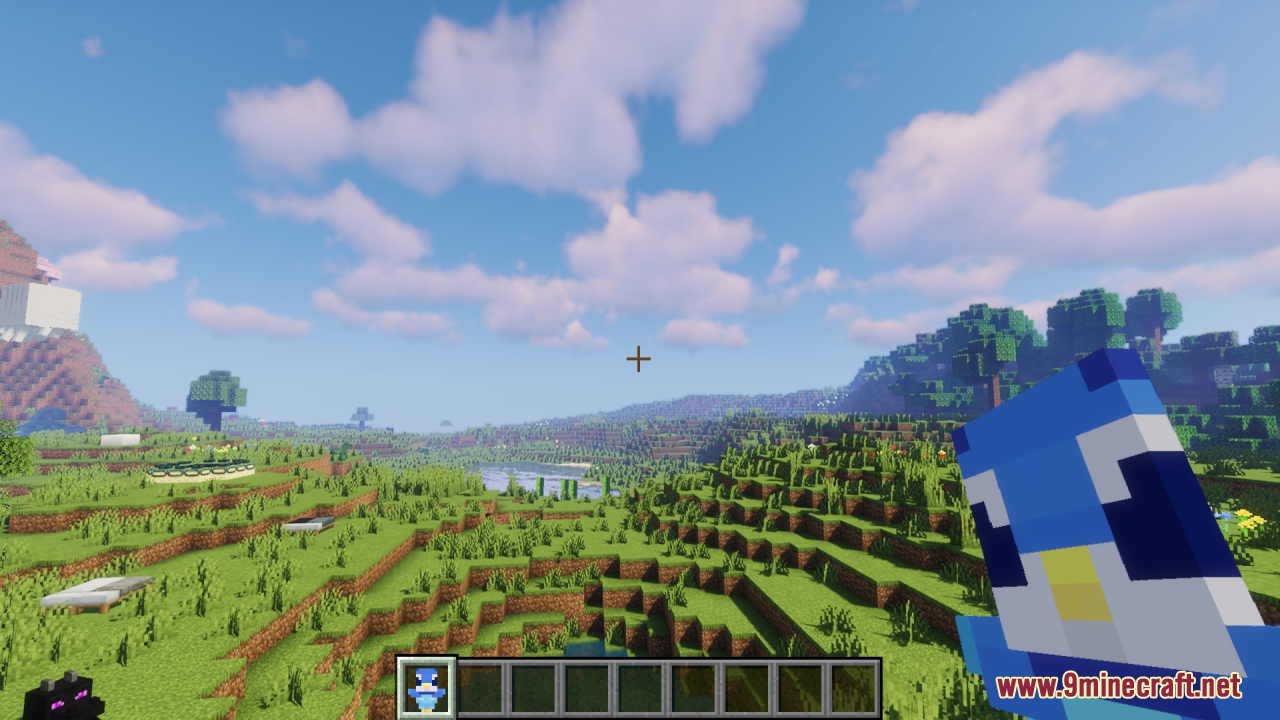 Piplup Totem of Undying Resource Pack Screenshot 1 A player holds a Piplup totem while looking at a scenic green valley