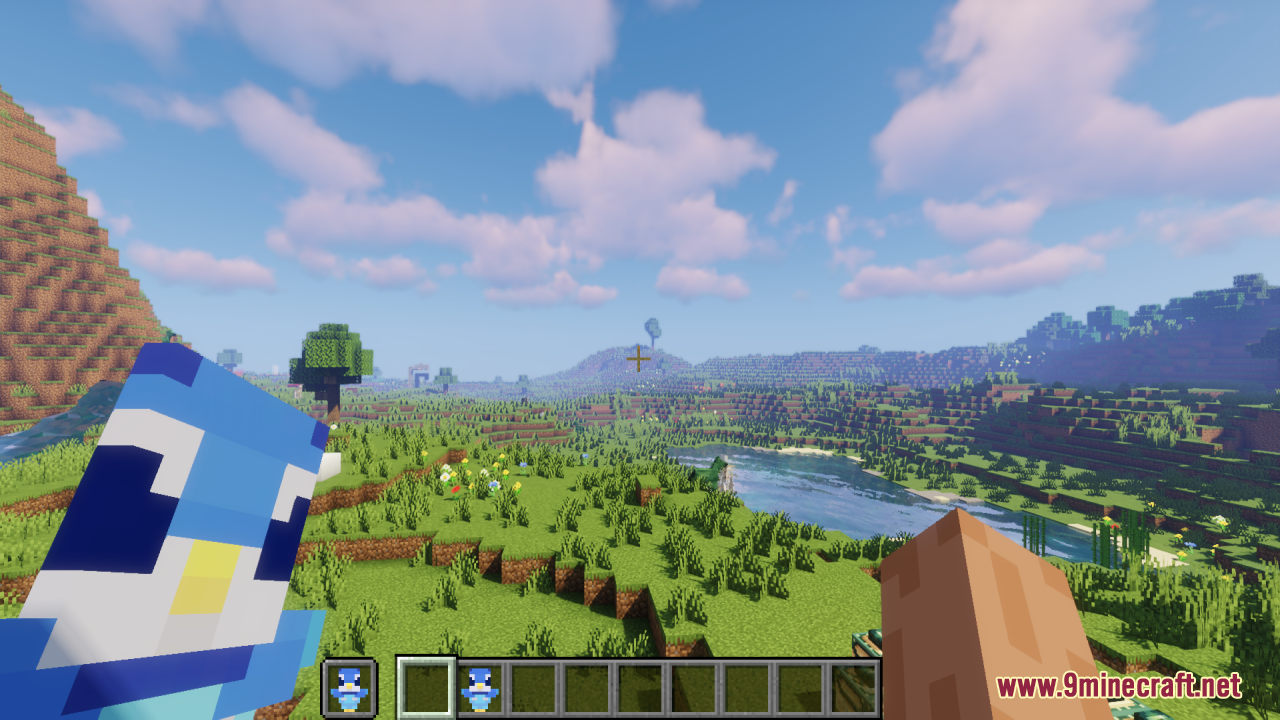Piplup Totem of Undying Resource Pack Screenshot 5 A player holds a cute Piplup totem while standing in a grassy field