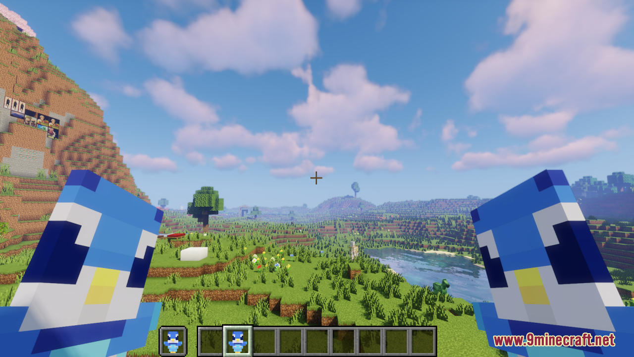 Piplup Totem of Undying Resource Pack Screenshot 6 Dual wielding two penguin totems while looking at a river and green hills