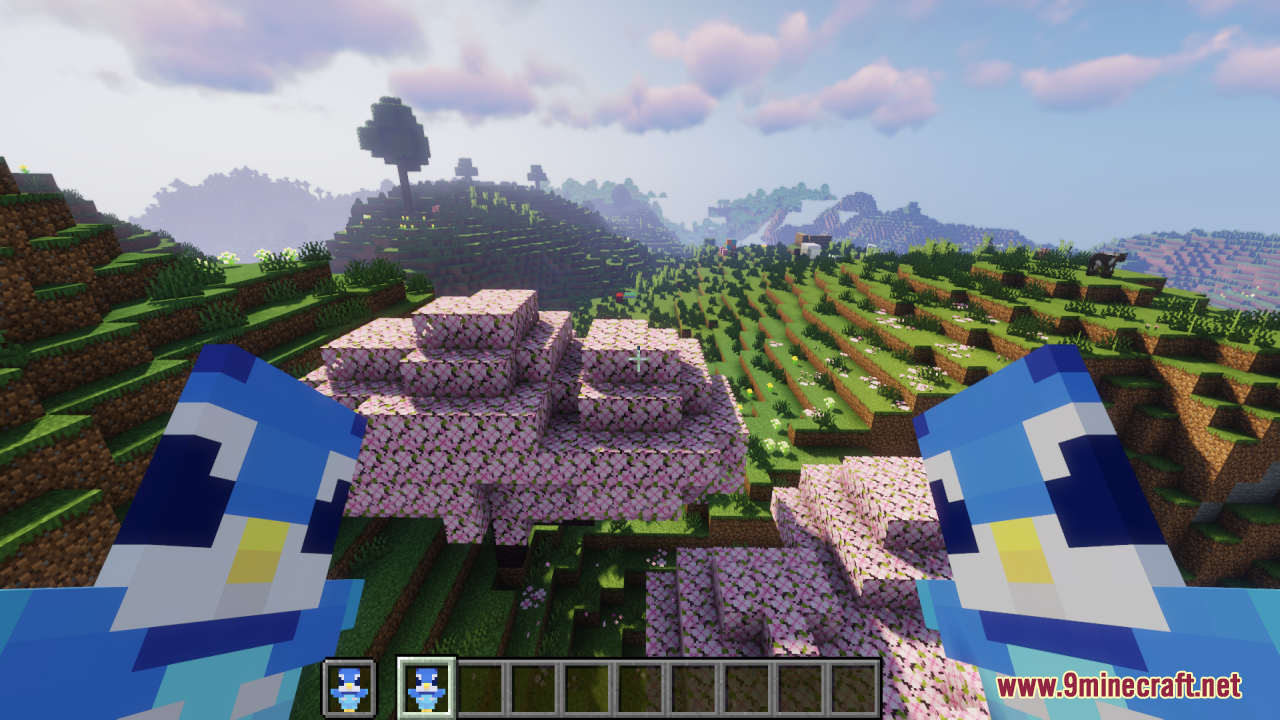 Piplup Totem of Undying Resource Pack Screenshot 9 Player holding two cute blue penguin totems while standing in a cherry grove