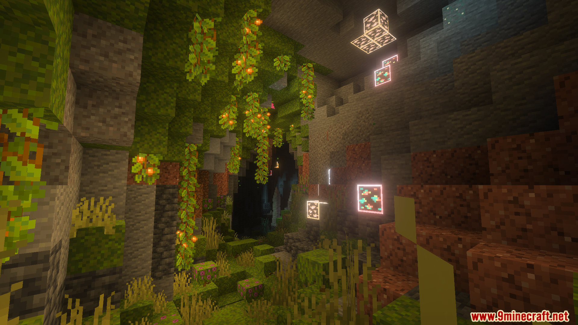 Glowing ore blocks illuminate the walls of a lush cave with hanging vines