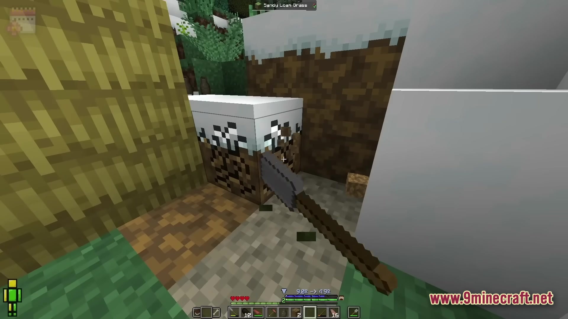 Realistic Craft Modpack Screenshot 3 A player uses a shovel to dig a snow-covered dirt block in a winter biome
