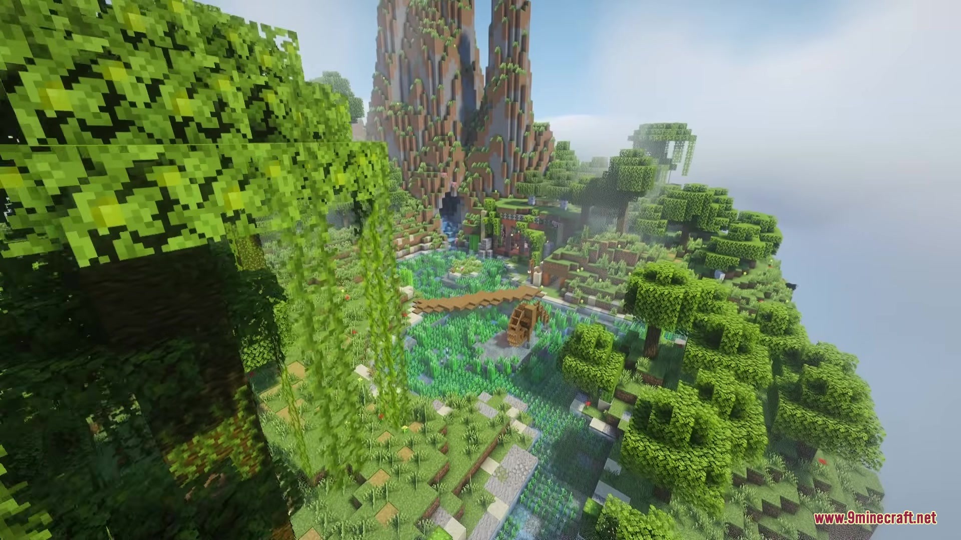 Reverse Eon Mod Screenshot 3 Lush green landscape with a water wheel and a small wooden bridge