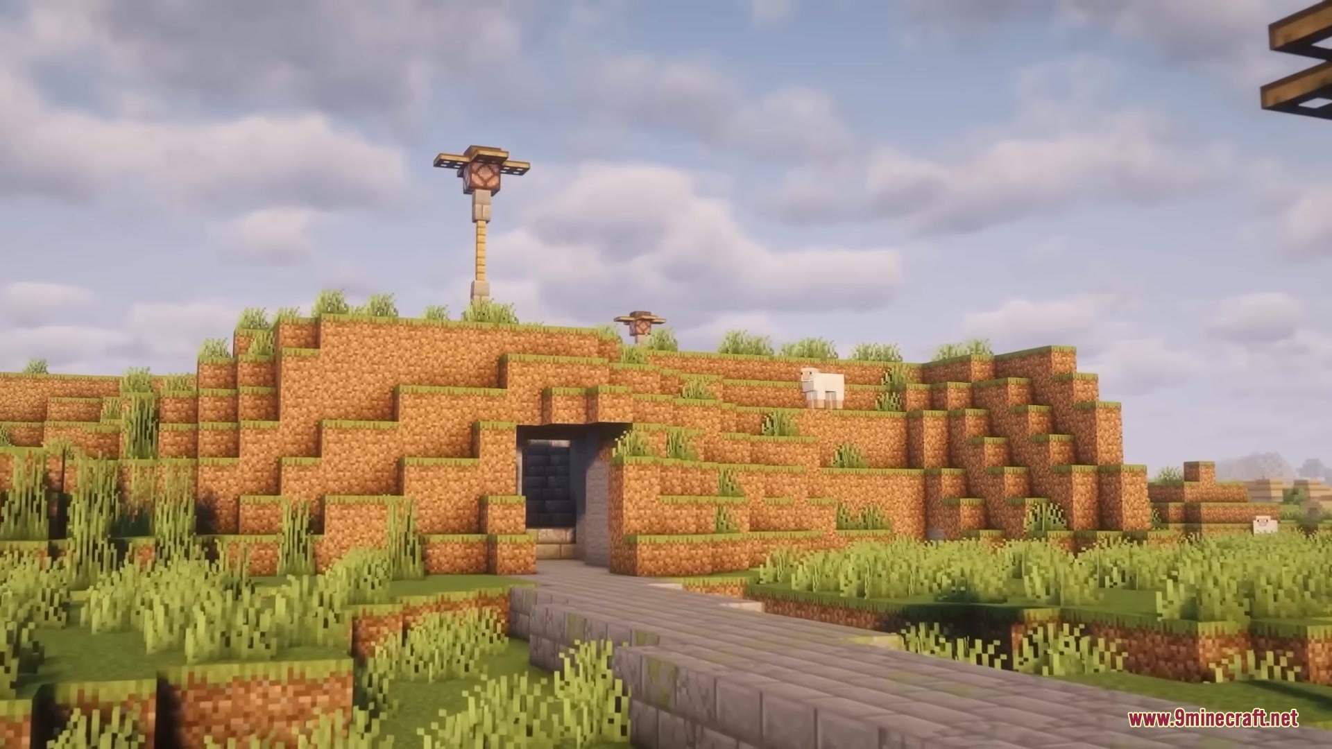 Stone brick path leads into a tunnel through a grassy Minecraft hill
