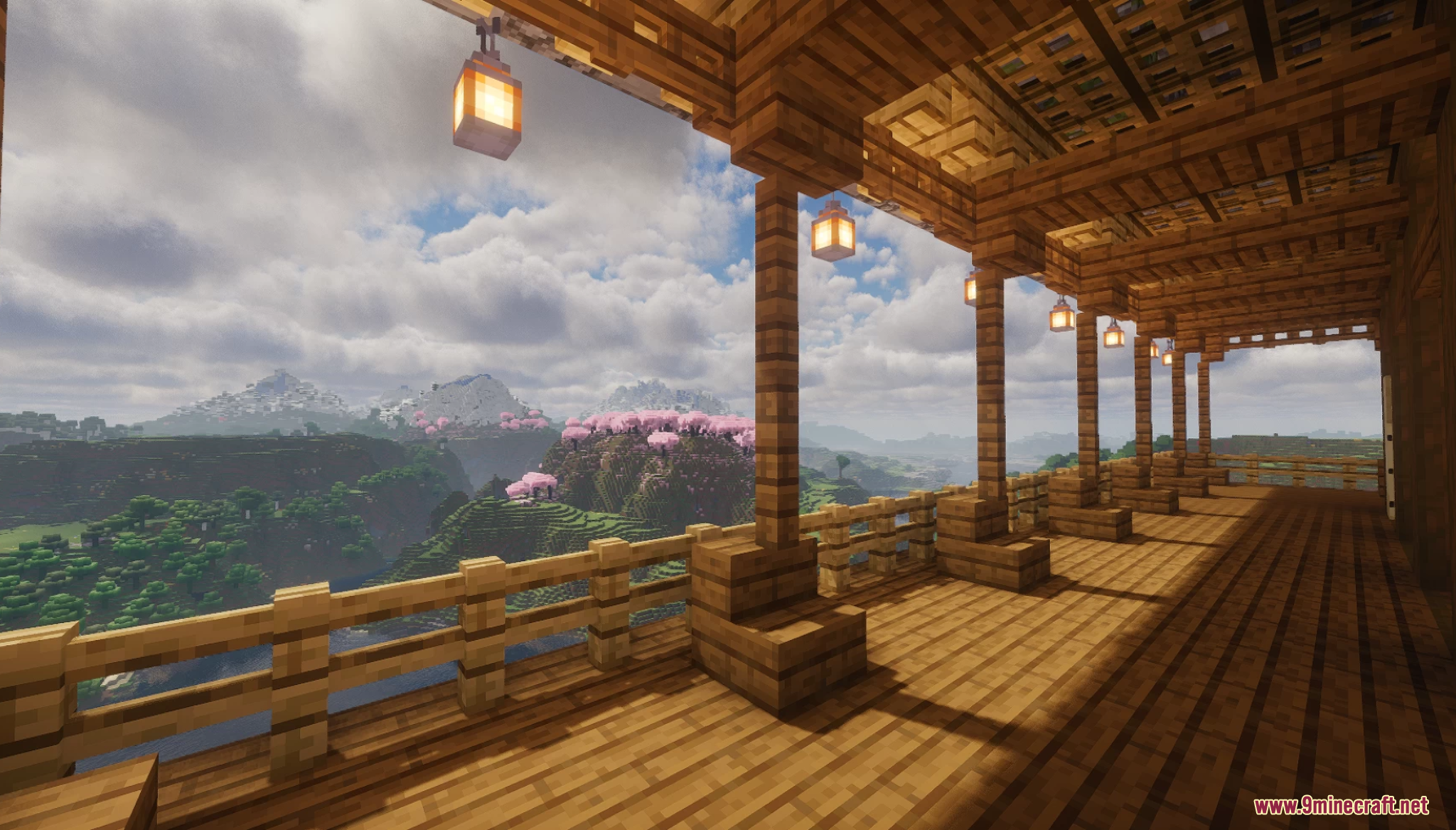 Wooden balcony overlooking a scenic valley with pink cherry blossom trees
