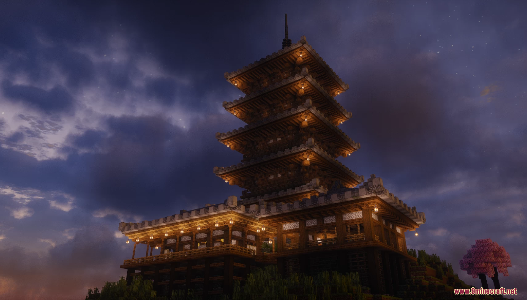 Large multi tiered Japanese pagoda glowing with lanterns during the night