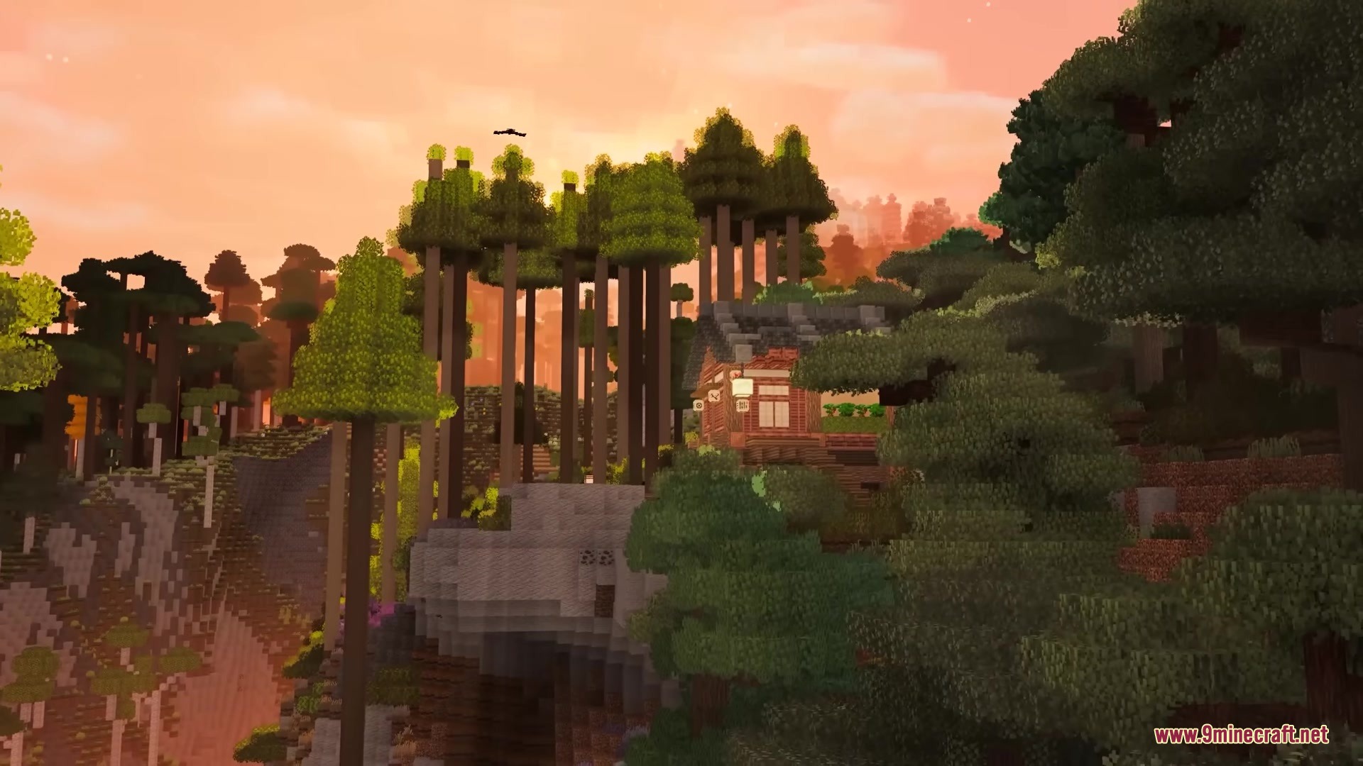 A traditional Japanese house stands among tall trees during a beautiful sunset