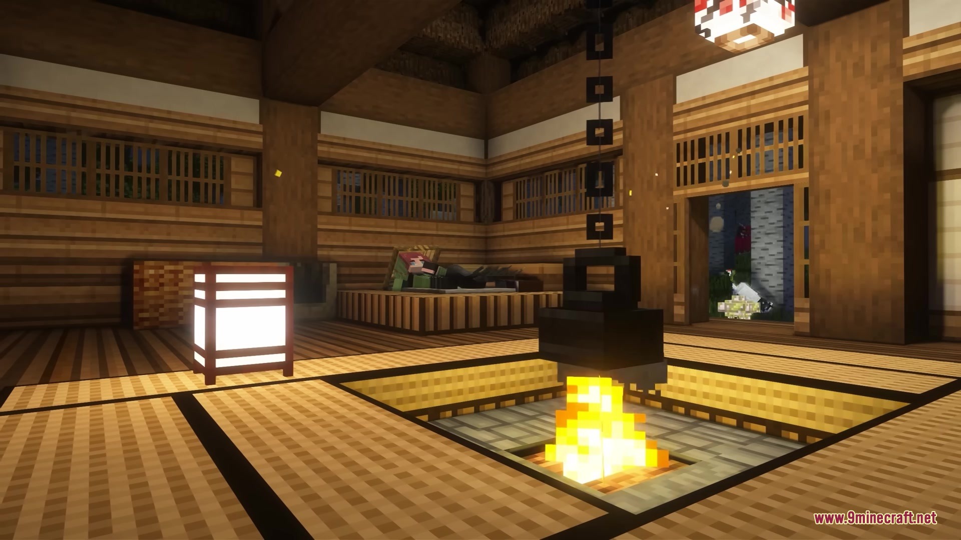 A cozy Japanese interior with a central fire pit and traditional paper lanterns