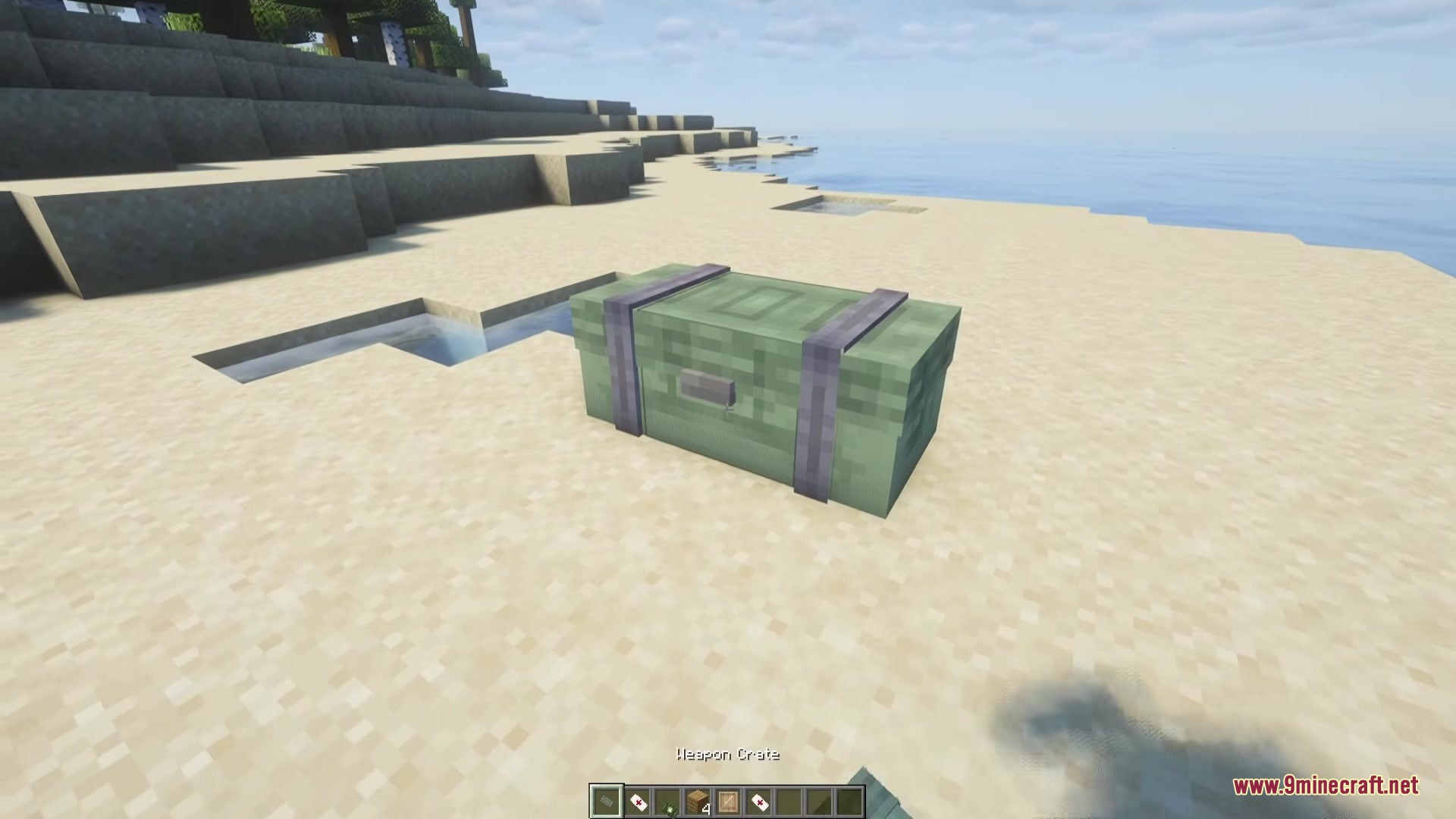Simply Airdrops Mod Screenshot 2 A single green weapon crate sitting alone on a sandy beach in Minecraft