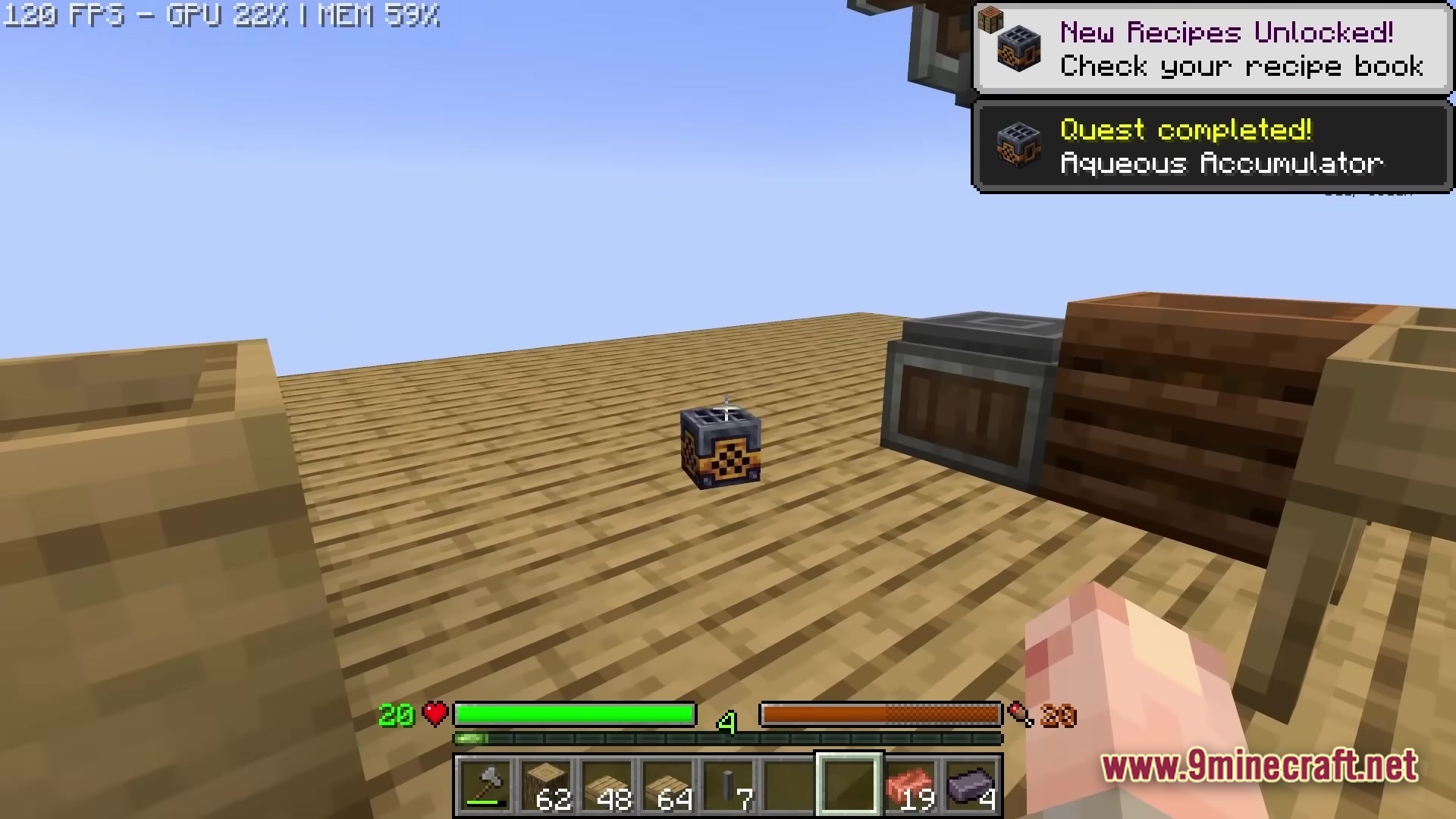 An Aqueous Accumulator block sits on a wooden platform with a quest completion notification displayed