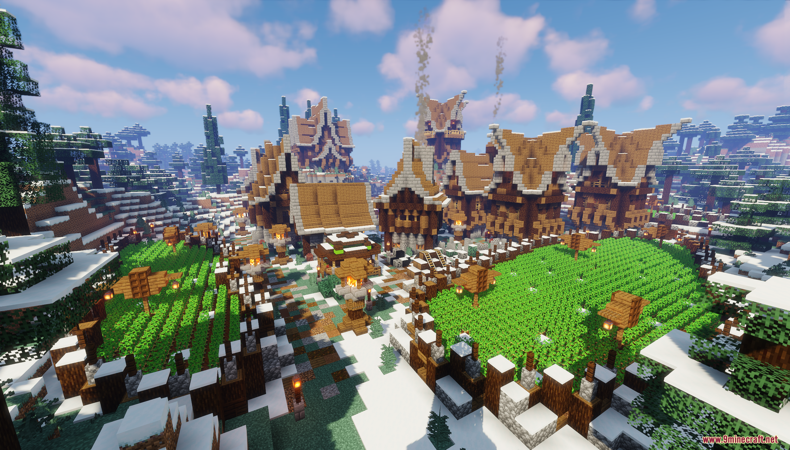 Lush green crop farms in front of wooden houses in a snowy village