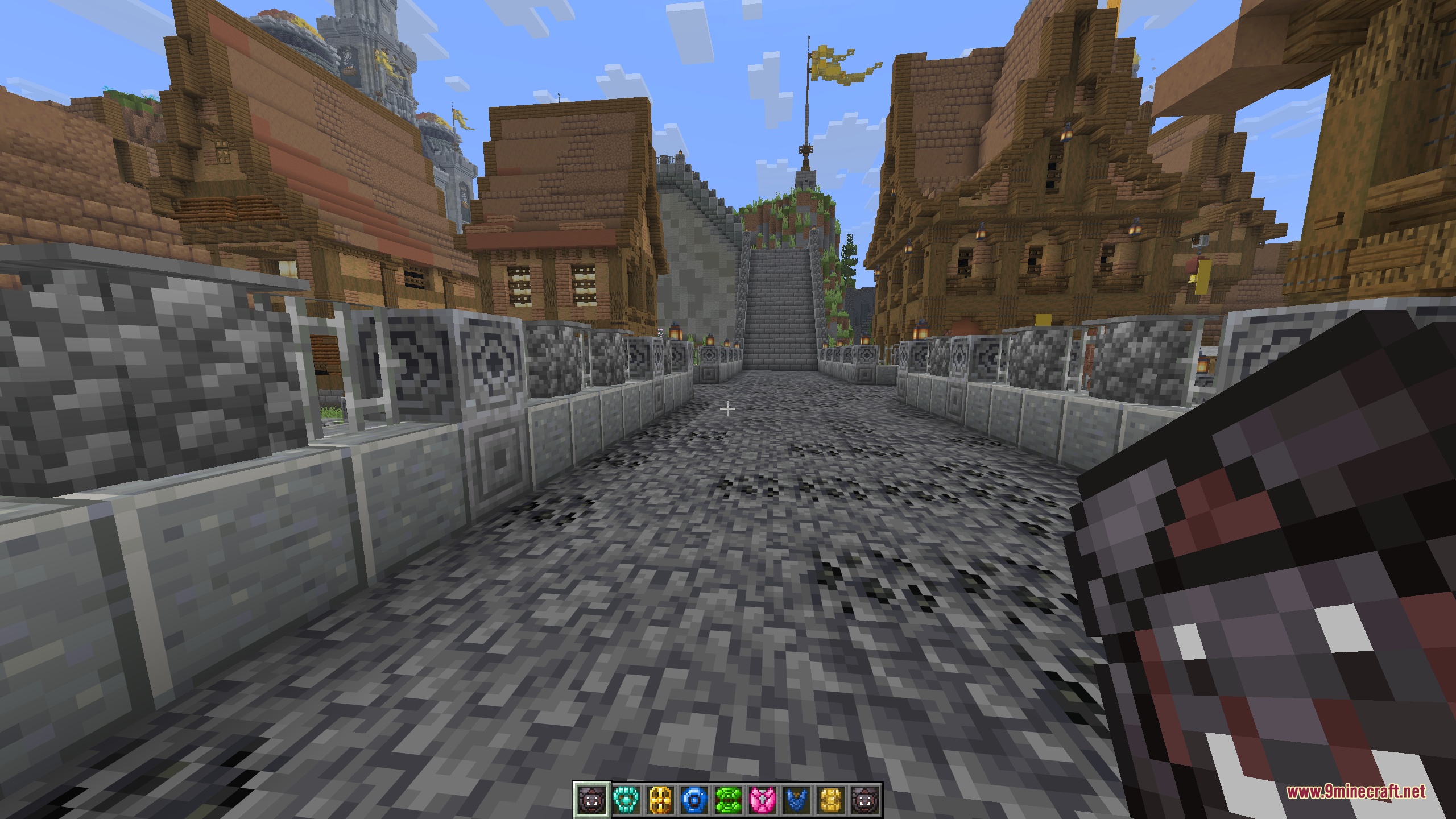A first-person view holding a dark crimson braced shield on a lantern-lit stone street leading up to a castle staircase