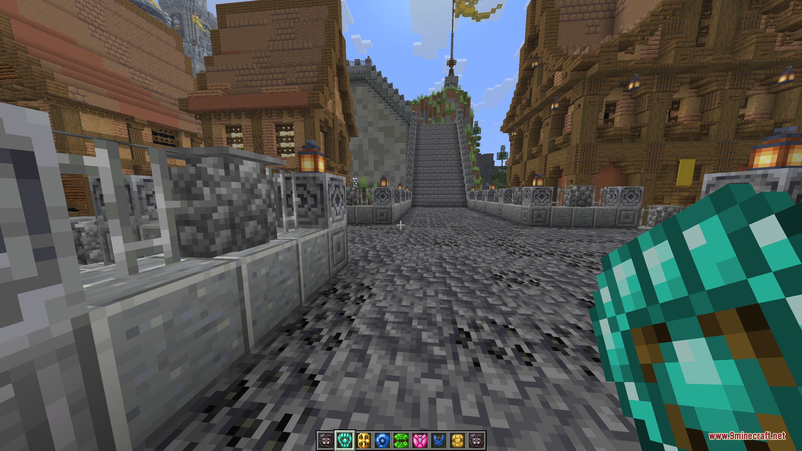 A first-person view holding a diamond-blue tower shield on a wide cobbled avenue lined with decorated stone railings
