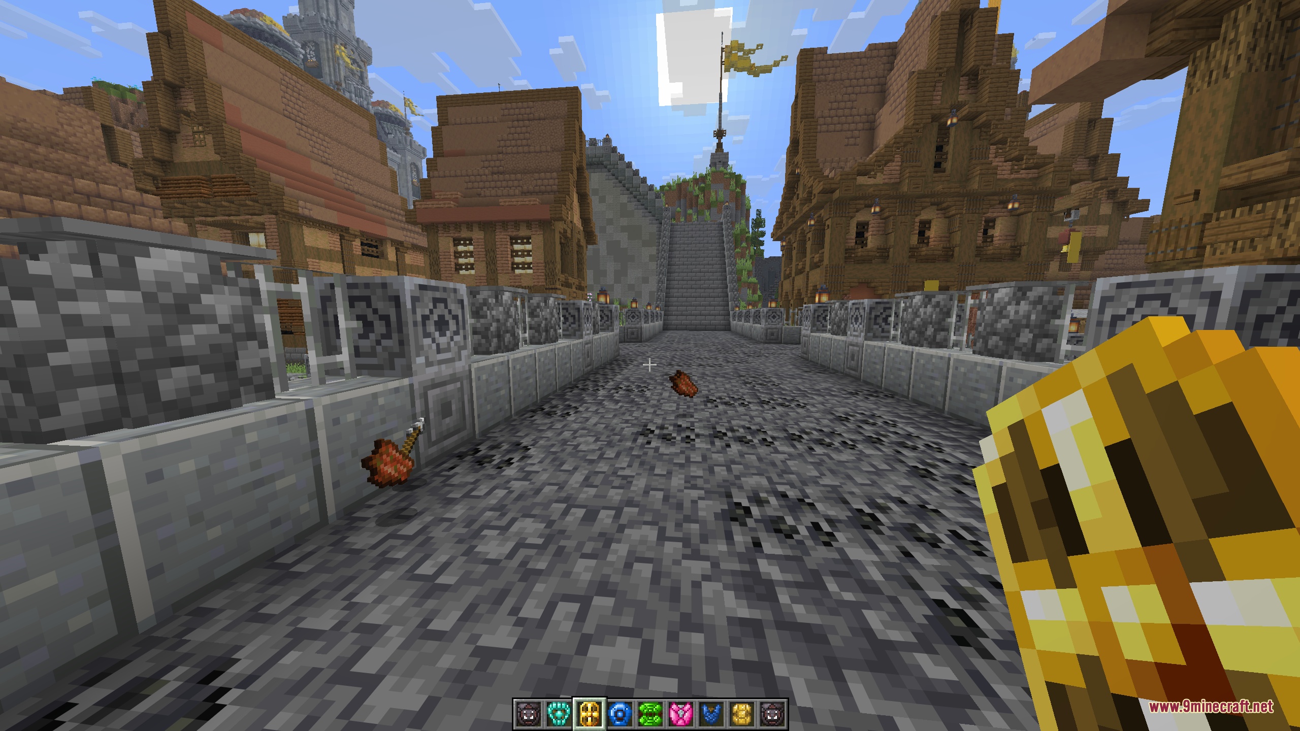 A first-person view holding a bright golden gilded shield on a town street beneath a banner-topped tower