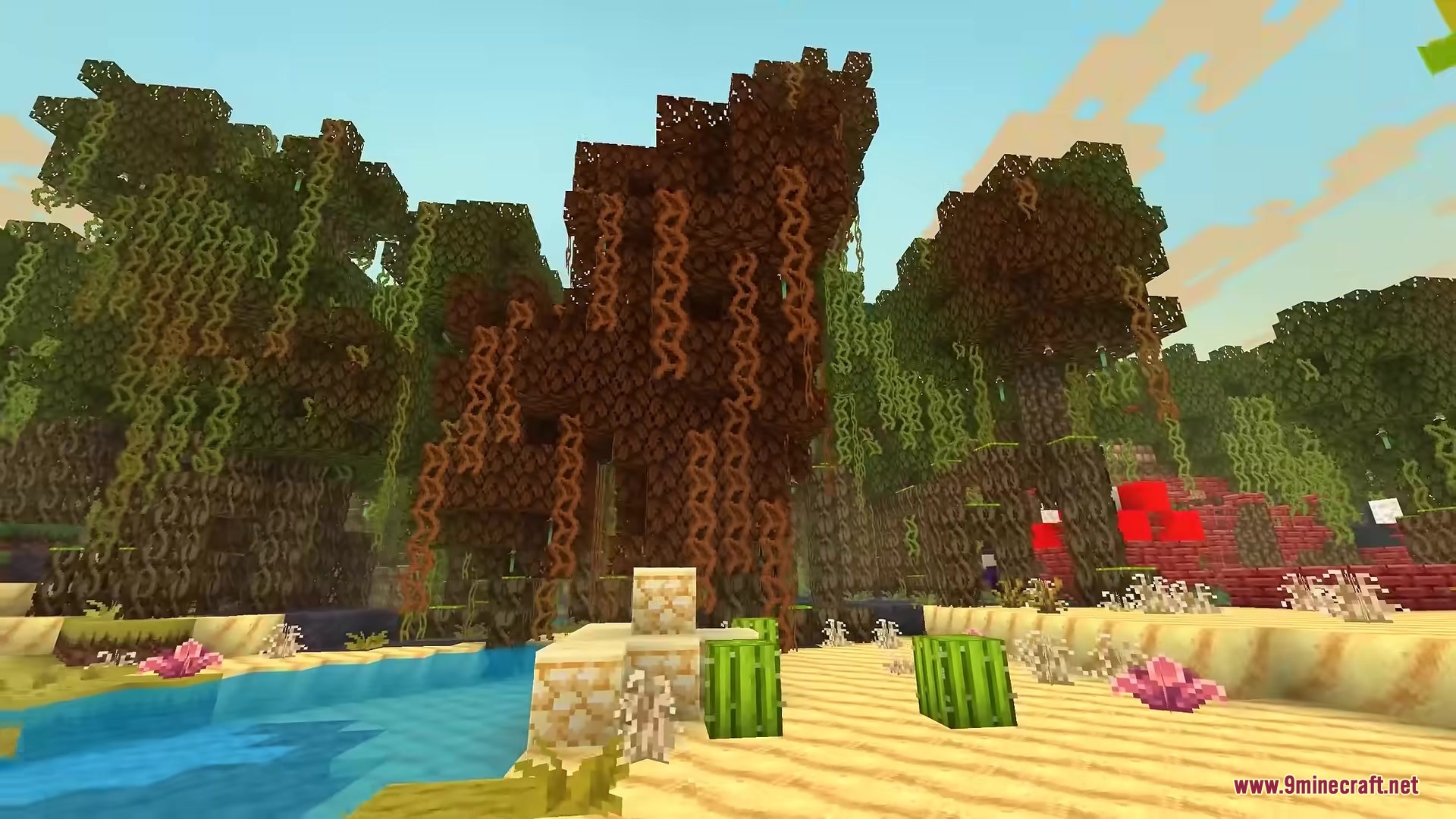 Vibrant trees with hanging vines grow along a bright sandy riverbank in Minecraft