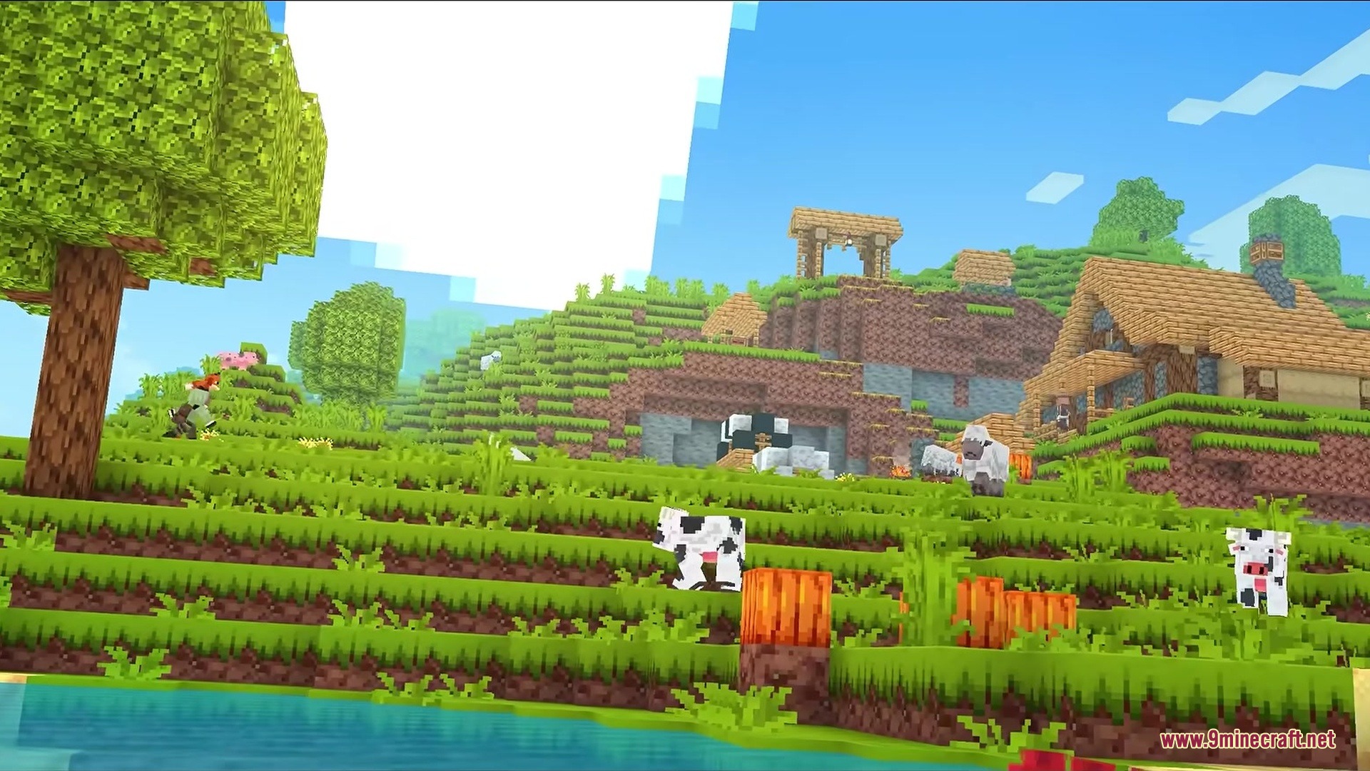 Cows graze on a vibrant green hillside near a cozy village house