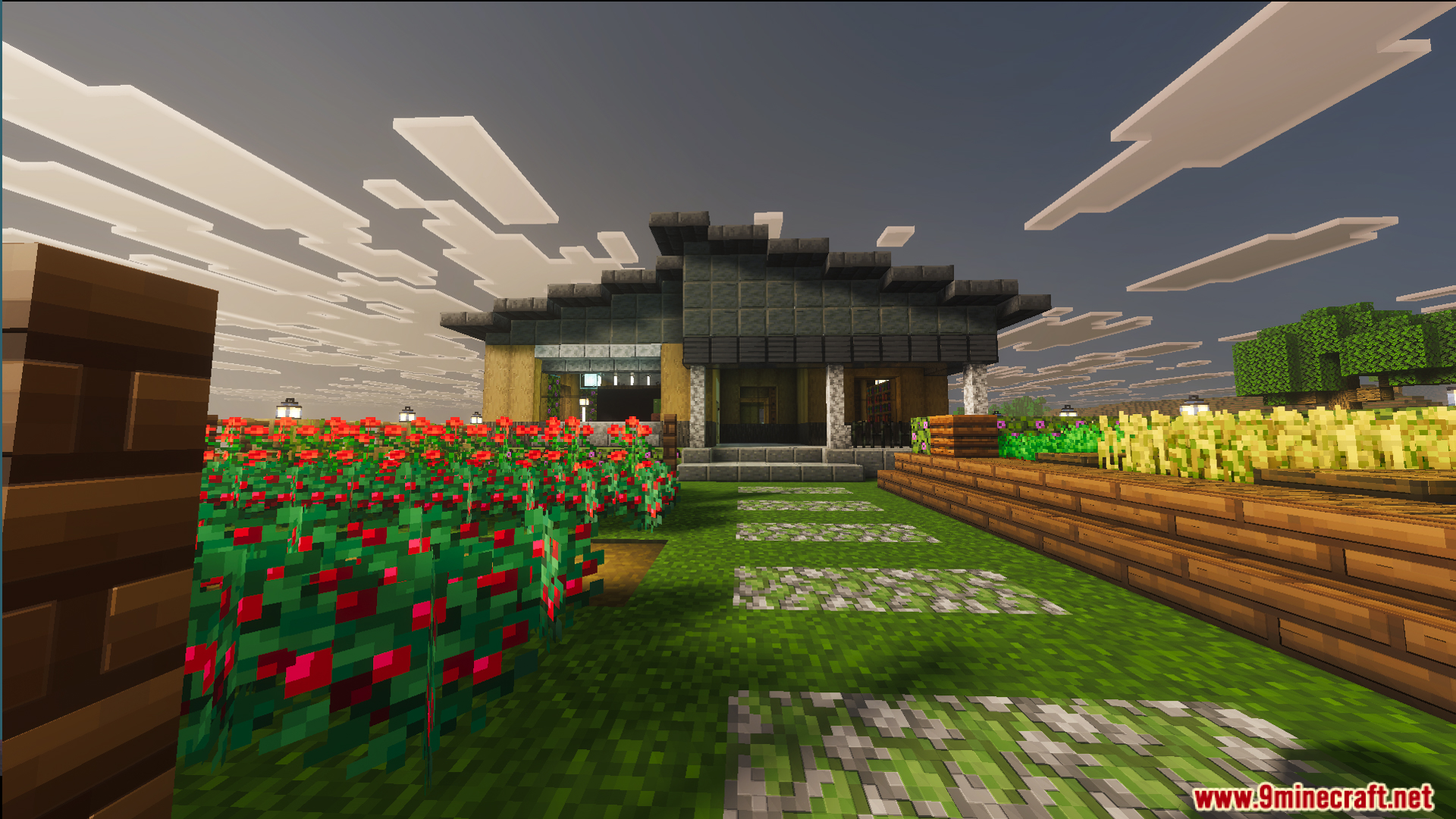 The front entrance of a modern house with flowers and stone paths