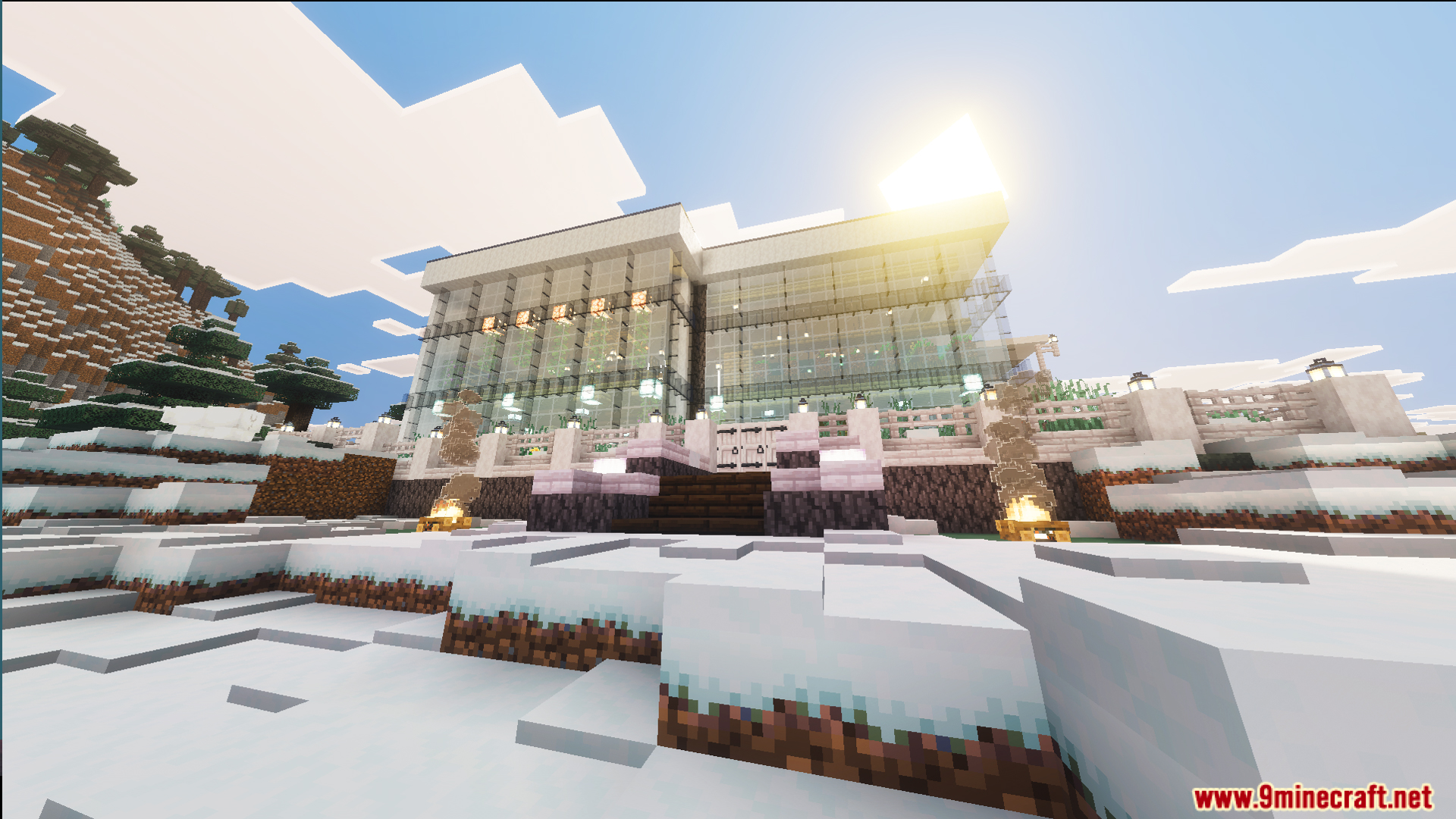A large glass building with campfires located in a beautiful cold snowy landscape