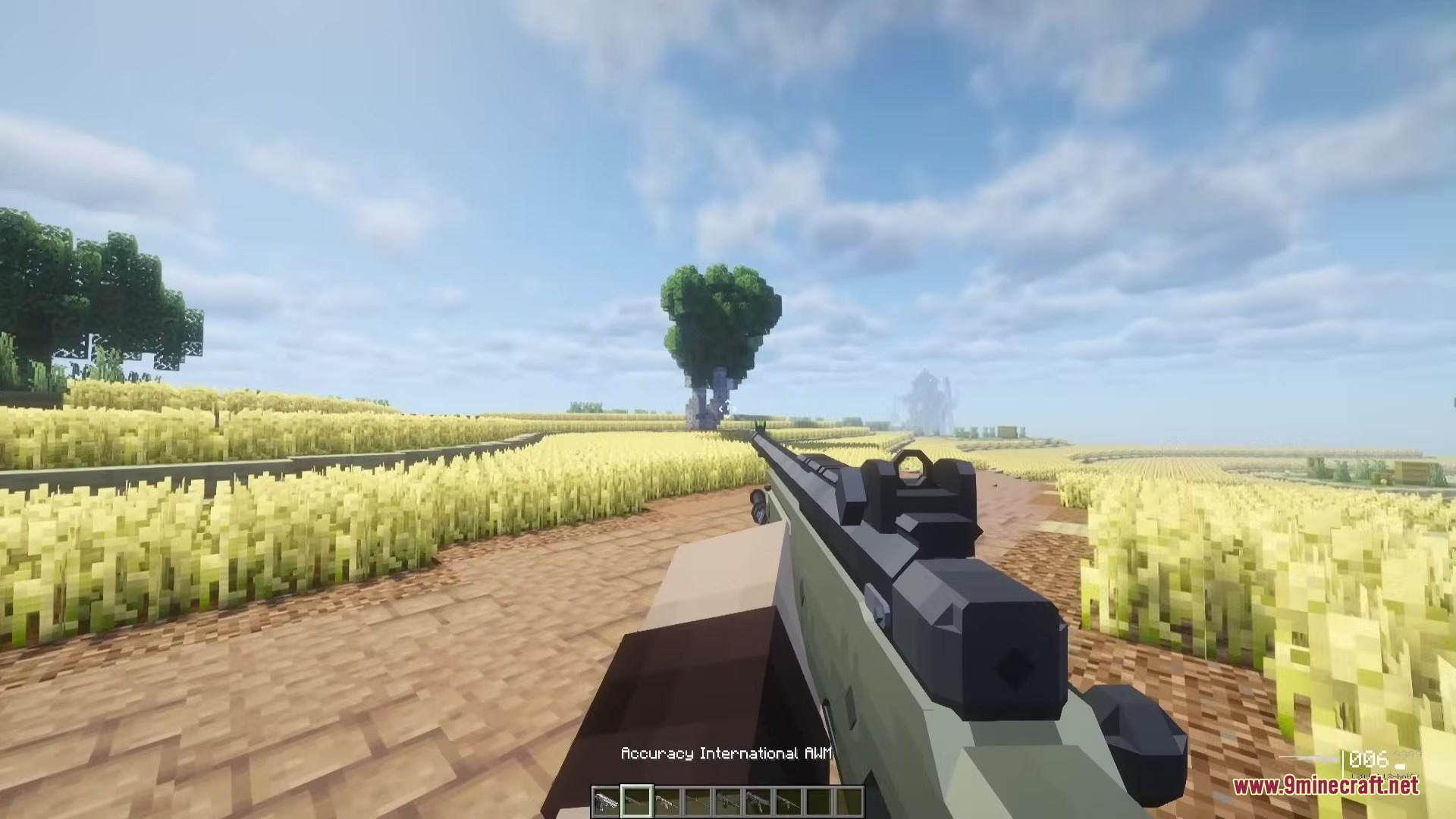 TaCZ Attributes Mod Screenshot 1 Player holding an Accuracy International AWM sniper rifle in a golden wheat field