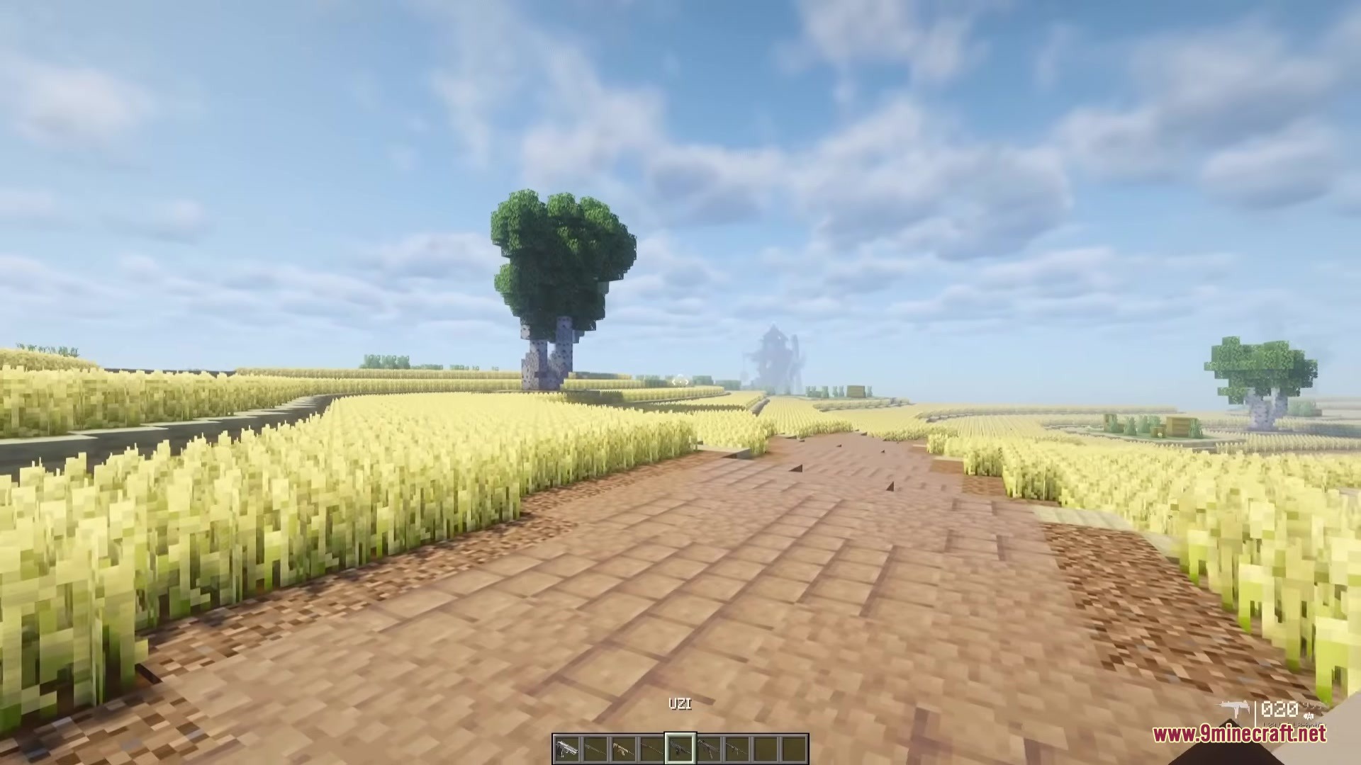 TaCZ Attributes Mod Screenshot 2 Player holding an Uzi submachine gun on a dirt path in Minecraft