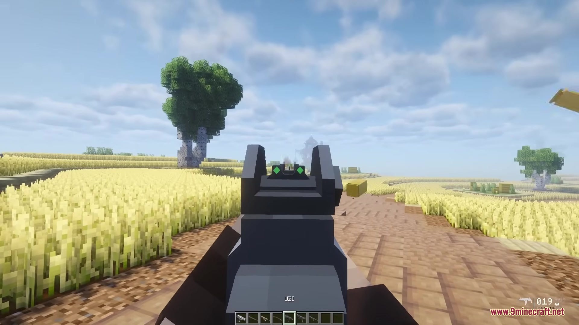 TaCZ Attributes Mod Screenshot 3 A player aims an Uzi down the sights in a wheat field