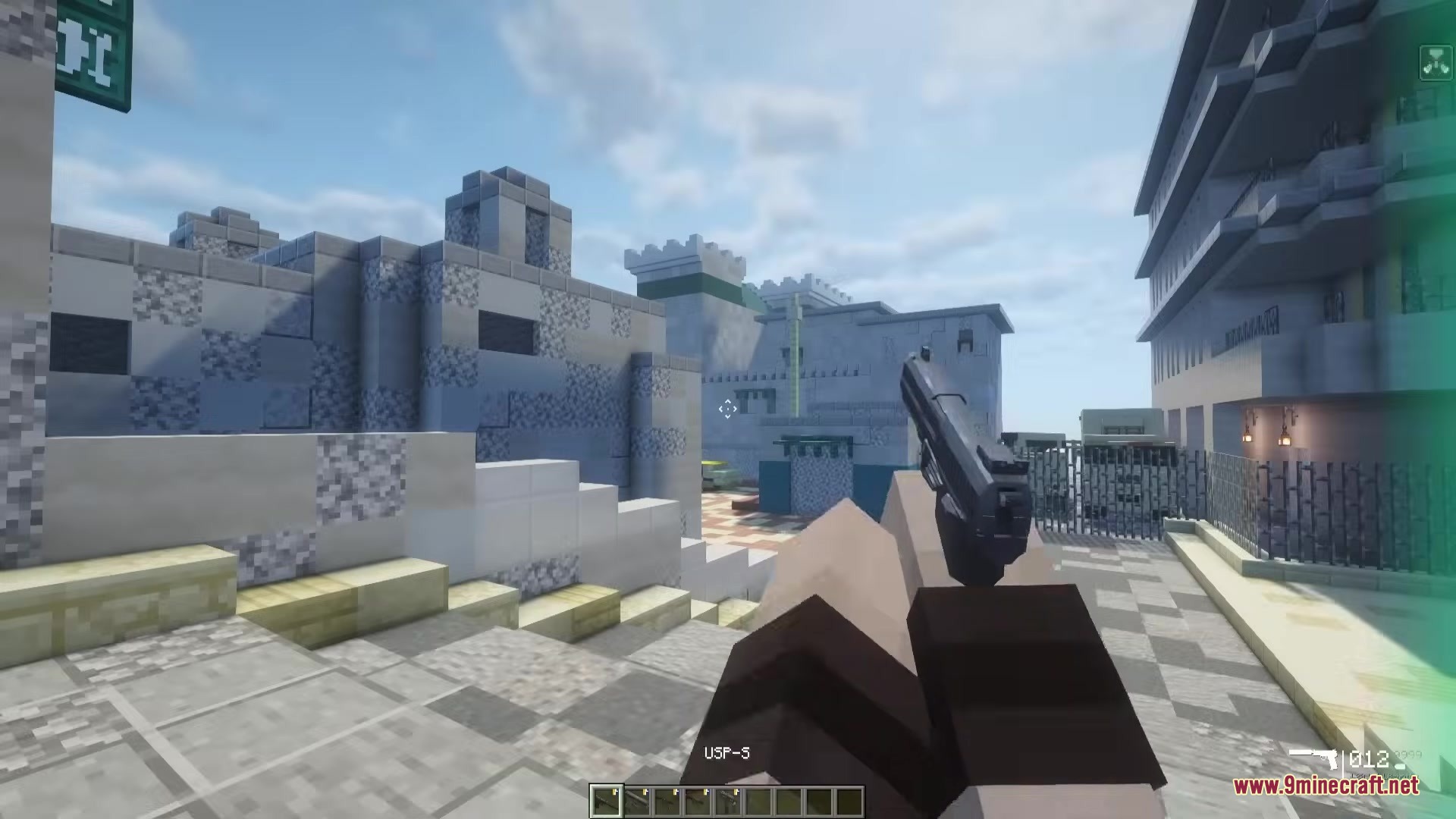 TaCZ CS Mod Screenshot 1 A player holding a USP pistol in a detailed Minecraft city map