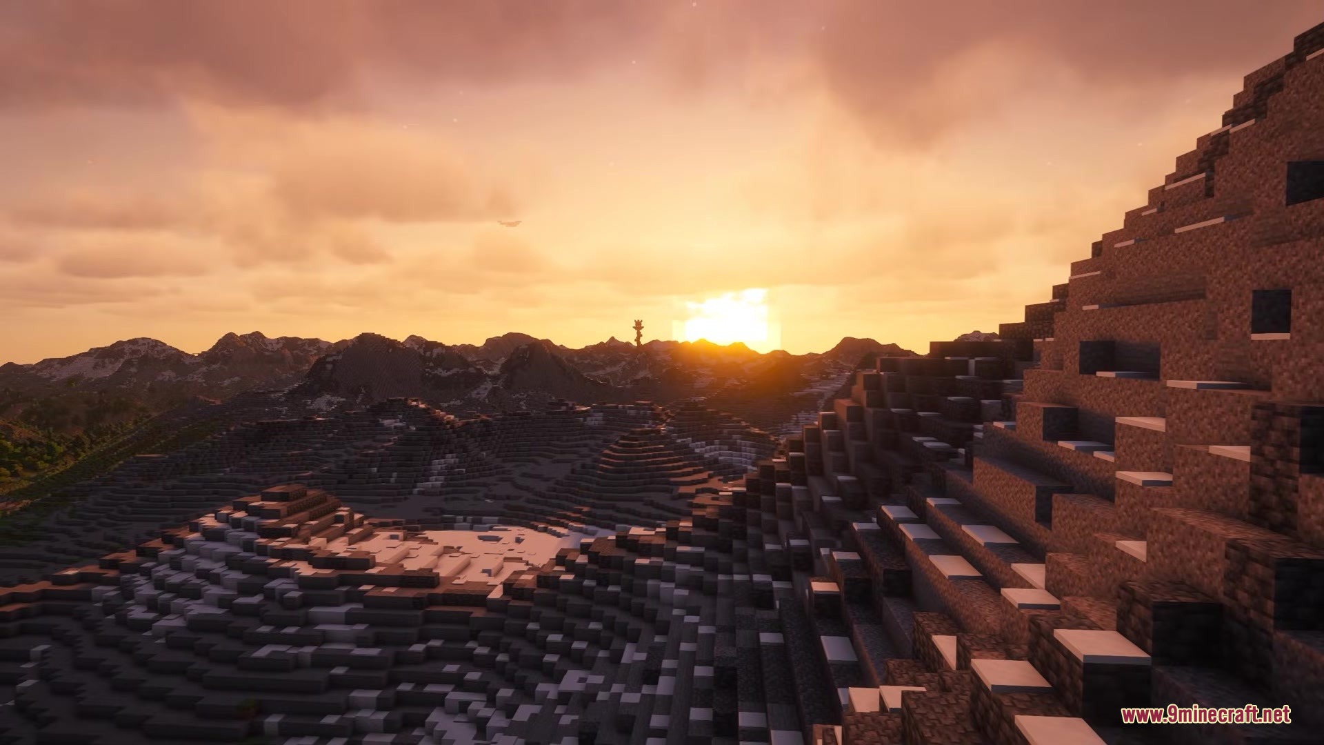 Stunning sunset over realistic mountain terrain with a distant tower silhouette